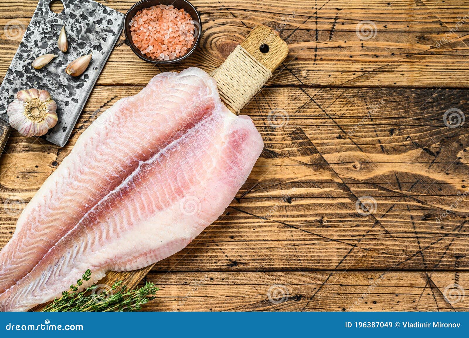 Raw Fillet of Pangasius Fish on a Cutting Board. Wooden Background
