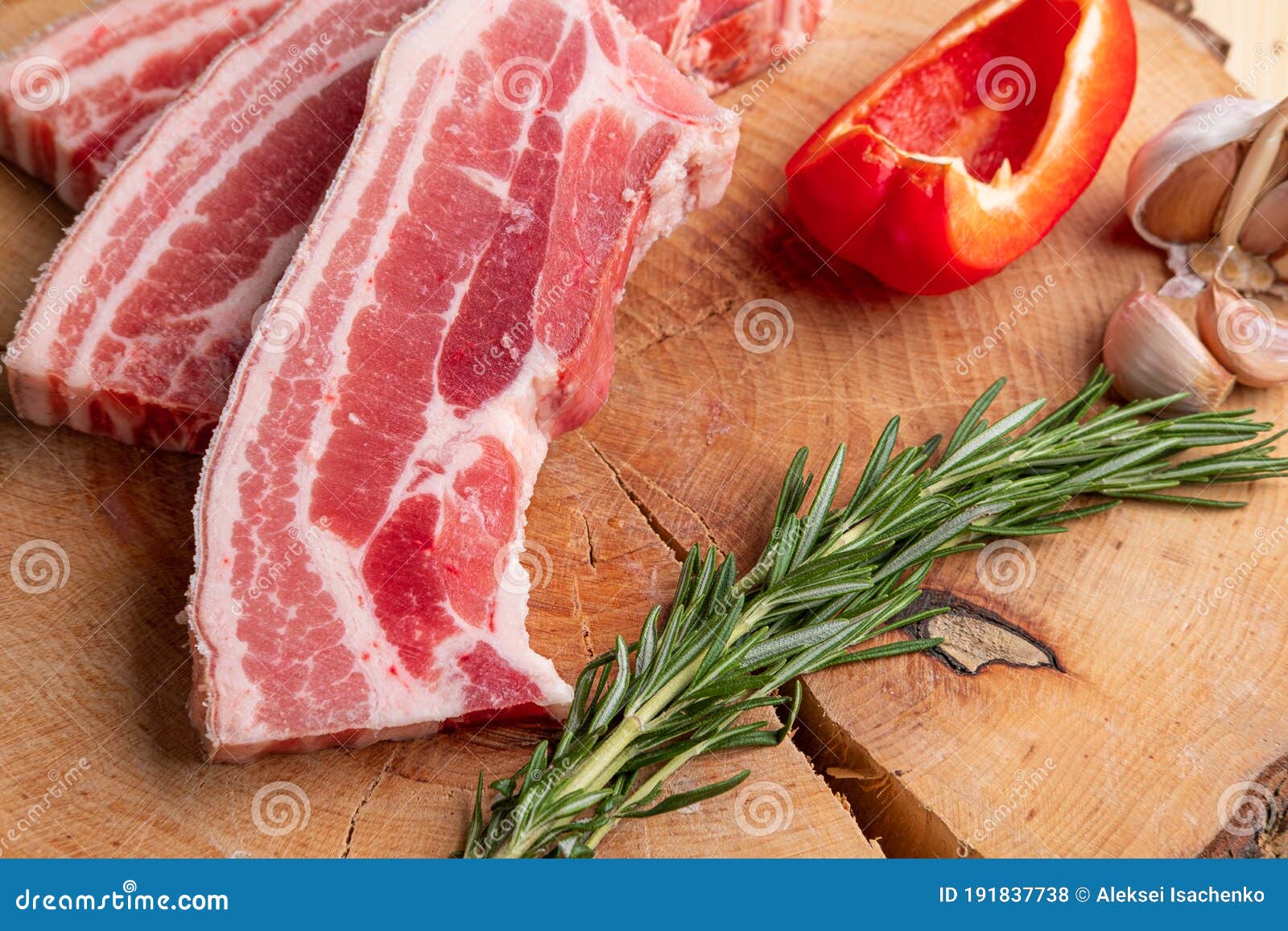 raw fresh pork brisket slices on wooden cutting board