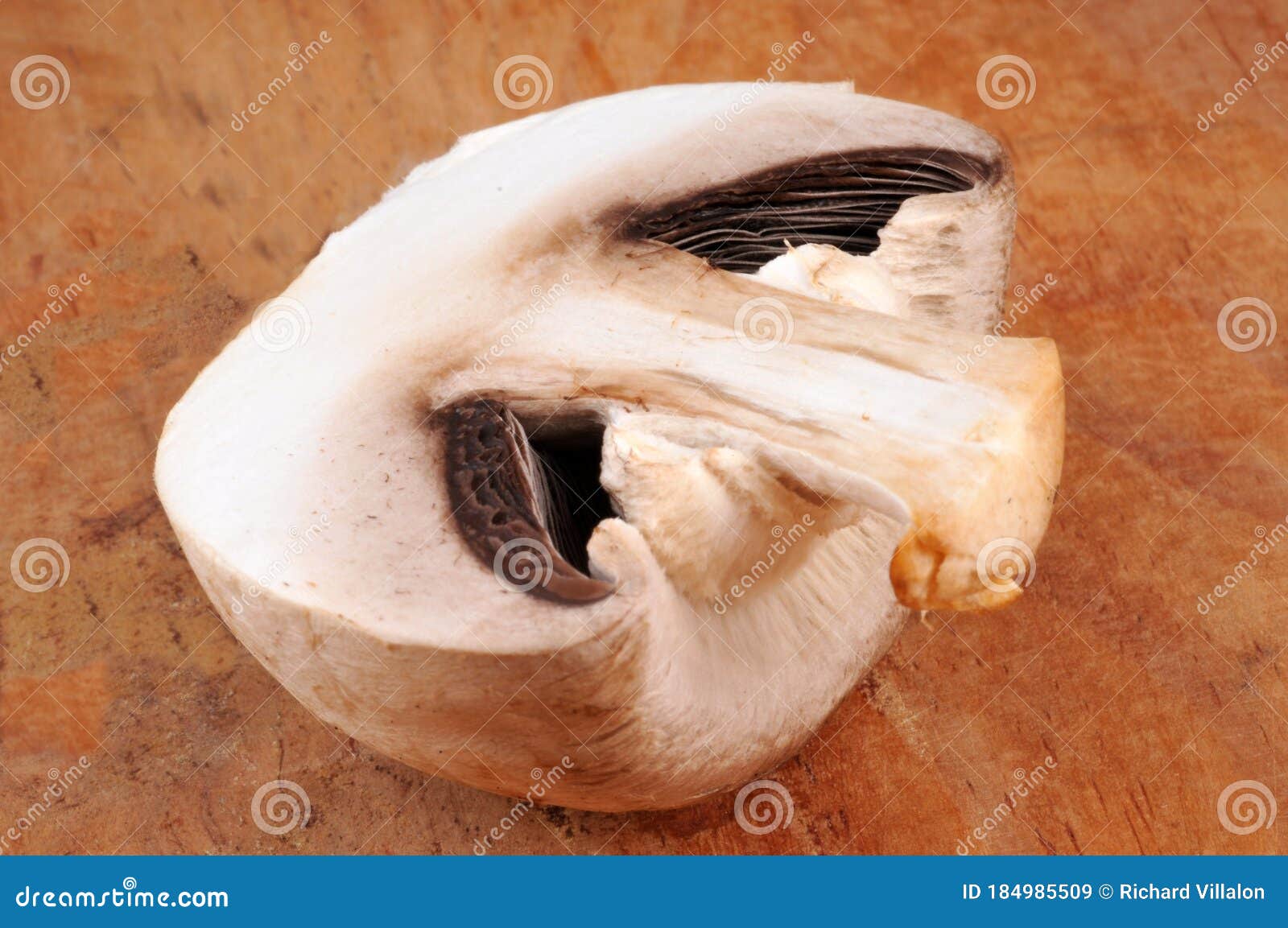 raw mushroom cut in half o nwooden background