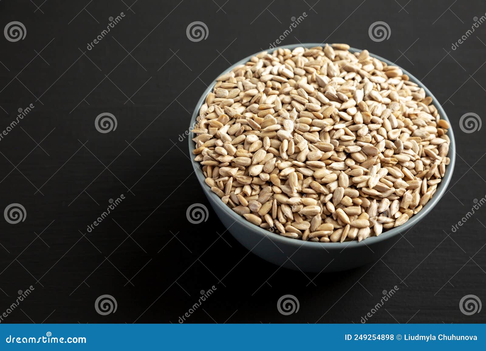 Raw Organic Sunflower Seed Kernels in a Blue Bowl, Side View. Space for Text Stock Photo Image
