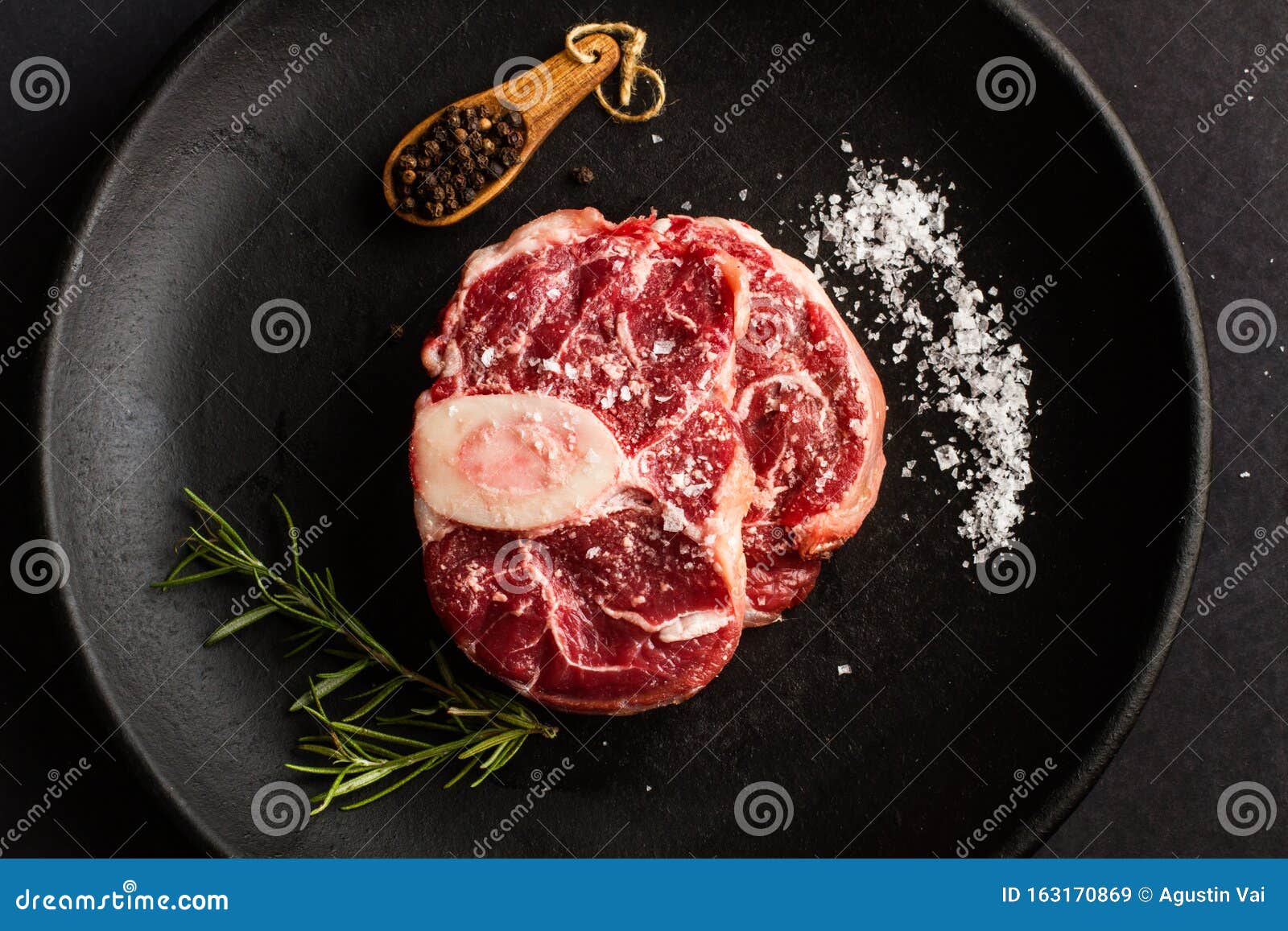 raw osso buco on a black plate