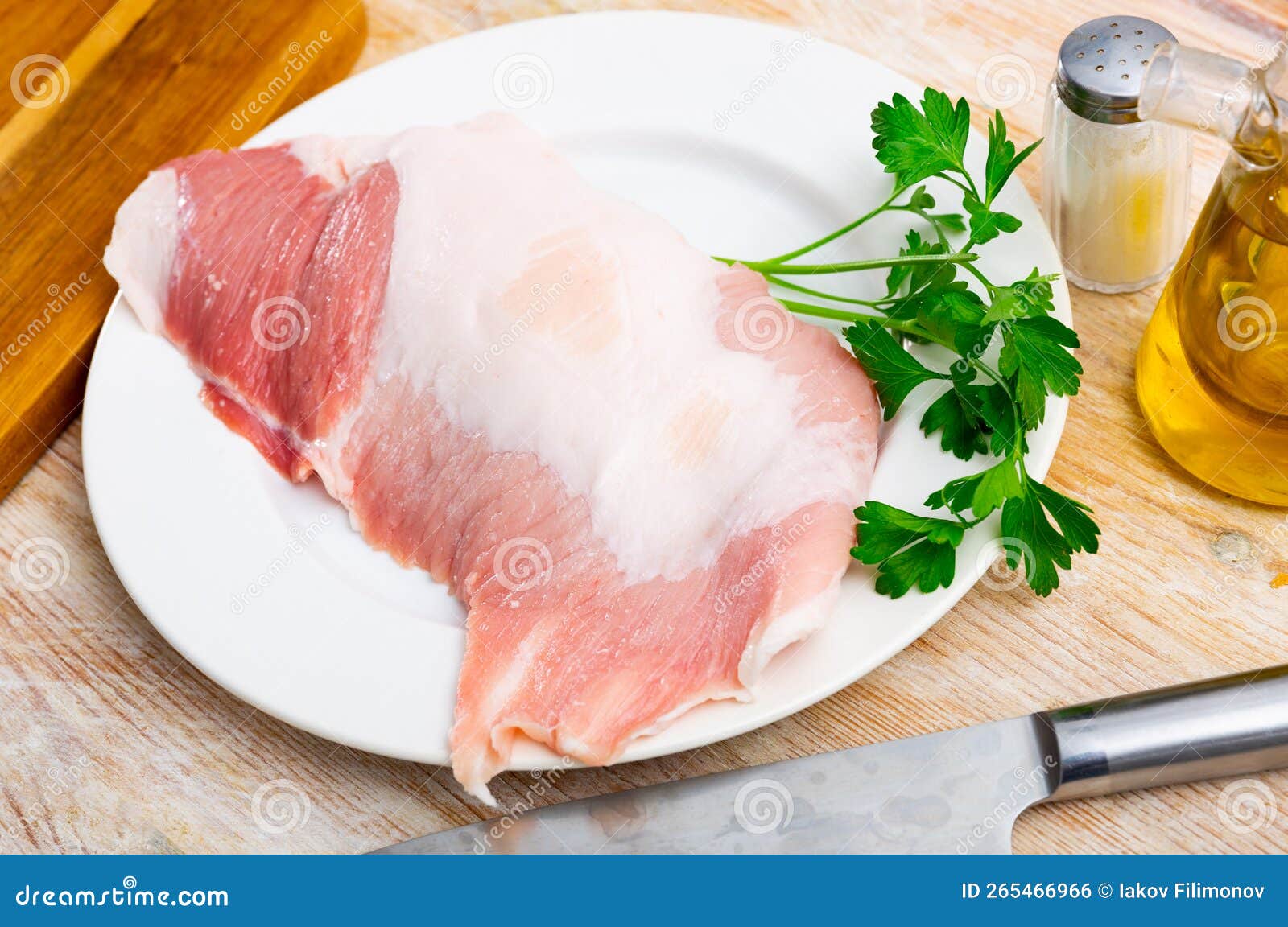 raw pork secreto fillet and condiments prepared for roasting on plate