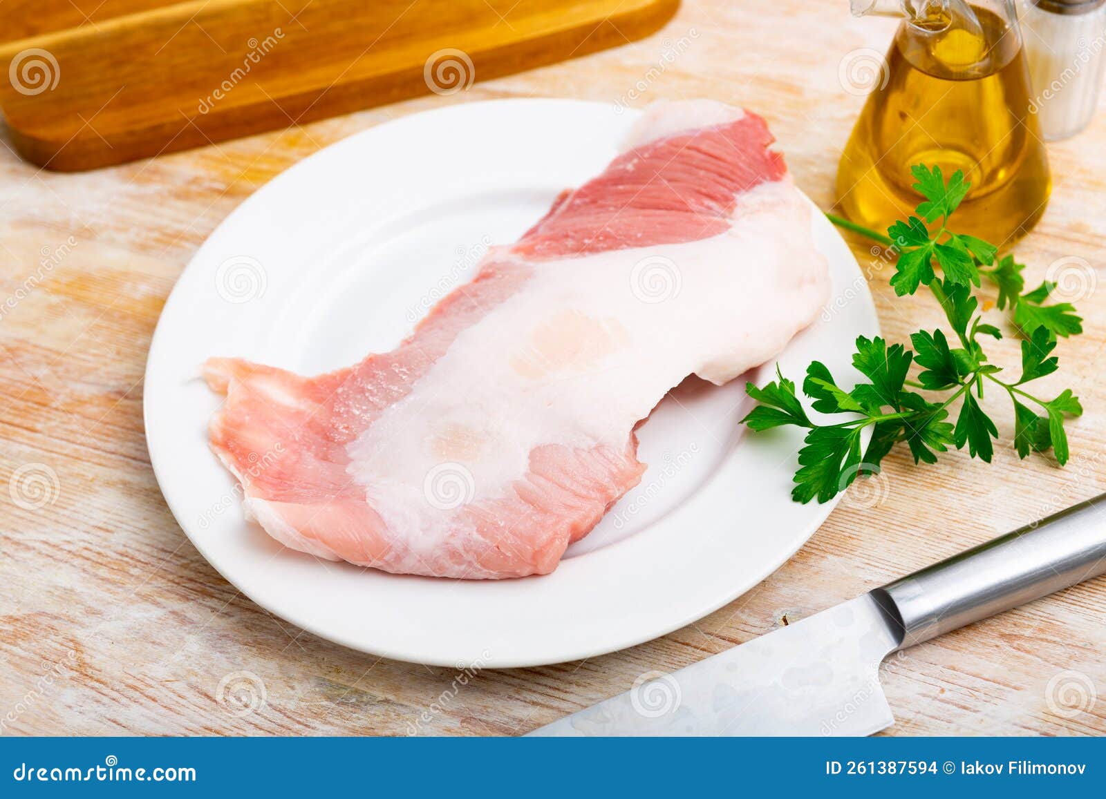 raw pork secreto steak and spices prepared for cooking on plate