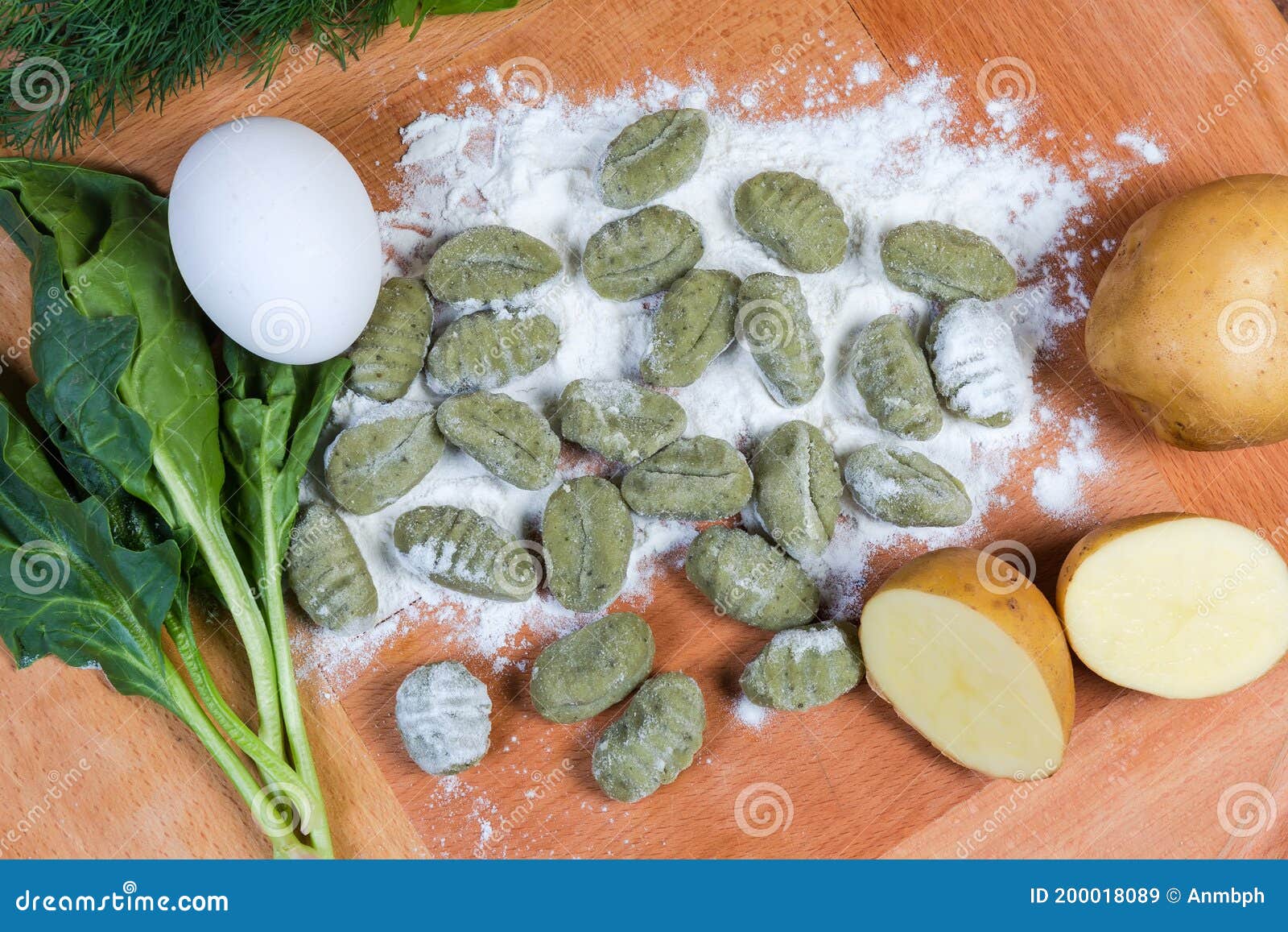 raw potato gnocchi with spinach in flour, ingredients, top view