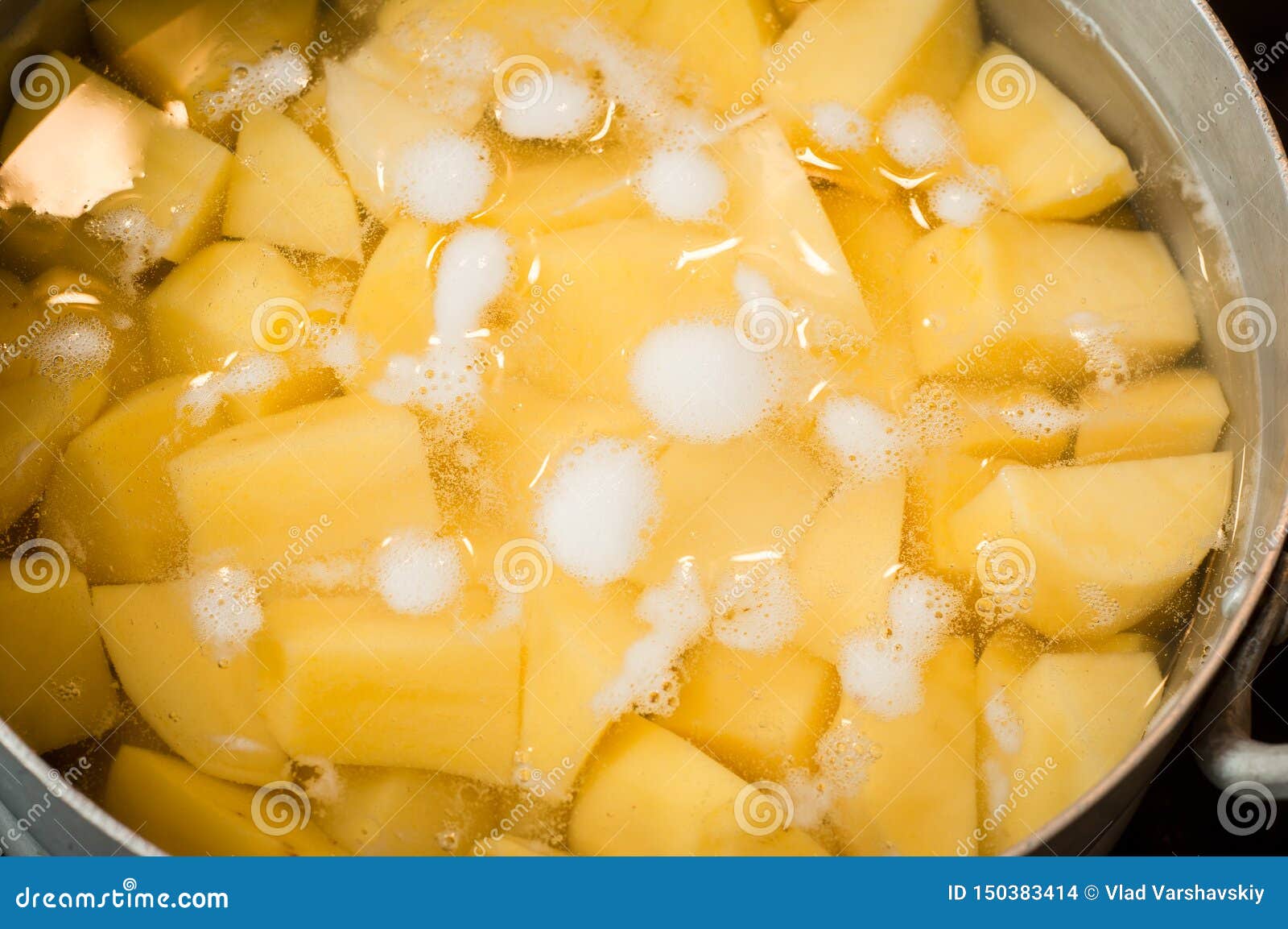 Raw Potatoes in Water before Boiling Foam in a Saucepan Stock Photo