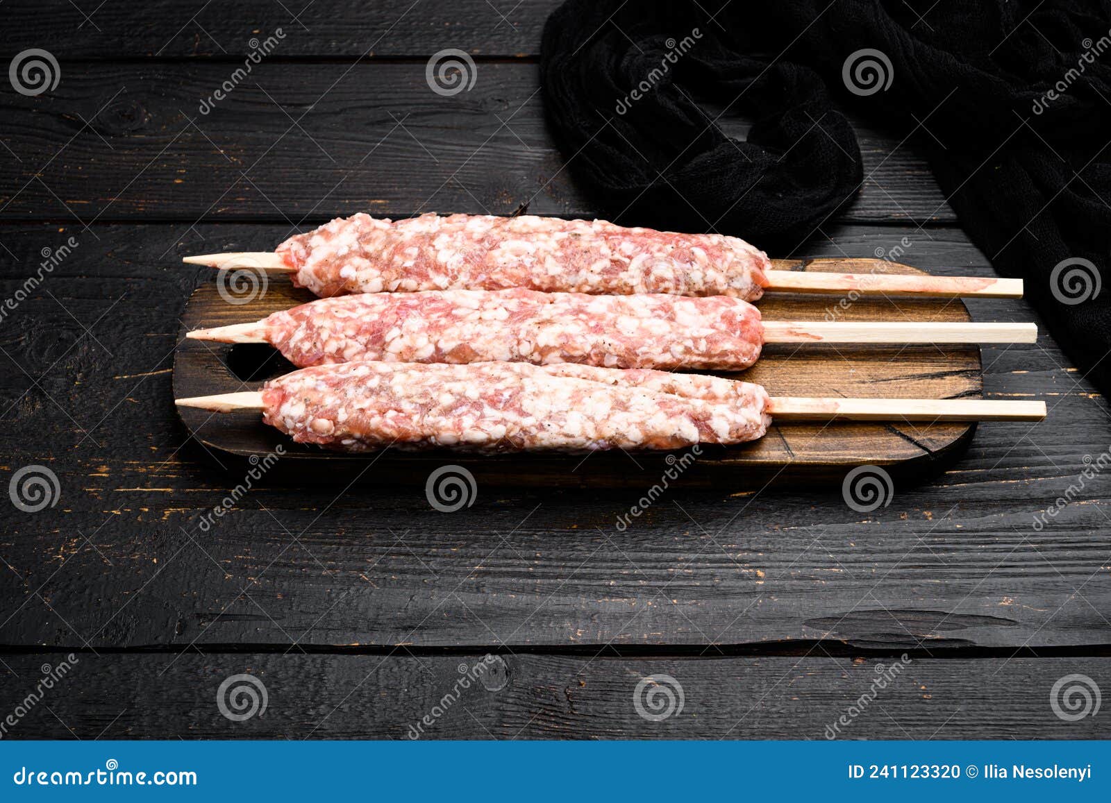 raw shish kebab skewers, on black wooden table background, with copy space for text