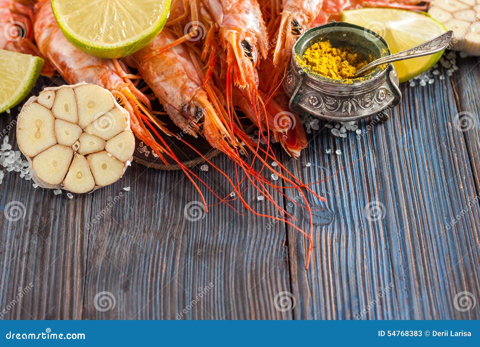 Raw shrimp, garlic, lime, curry and sea salt on a dark wooden background. Ingredients. Seafood. Raw fresh shrimp, garlic, lime and sea salt on a dark wooden background. Copy-space