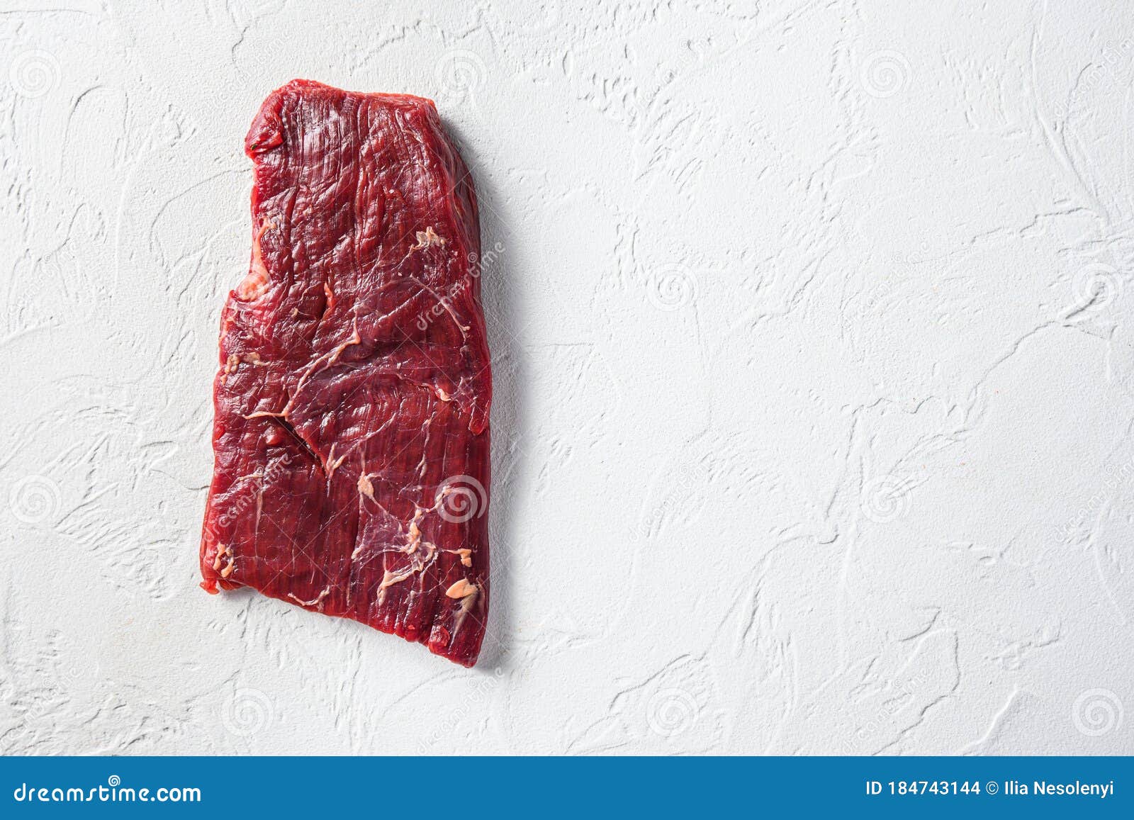 raw skirt or flank steak,on a white stone background top view space for text