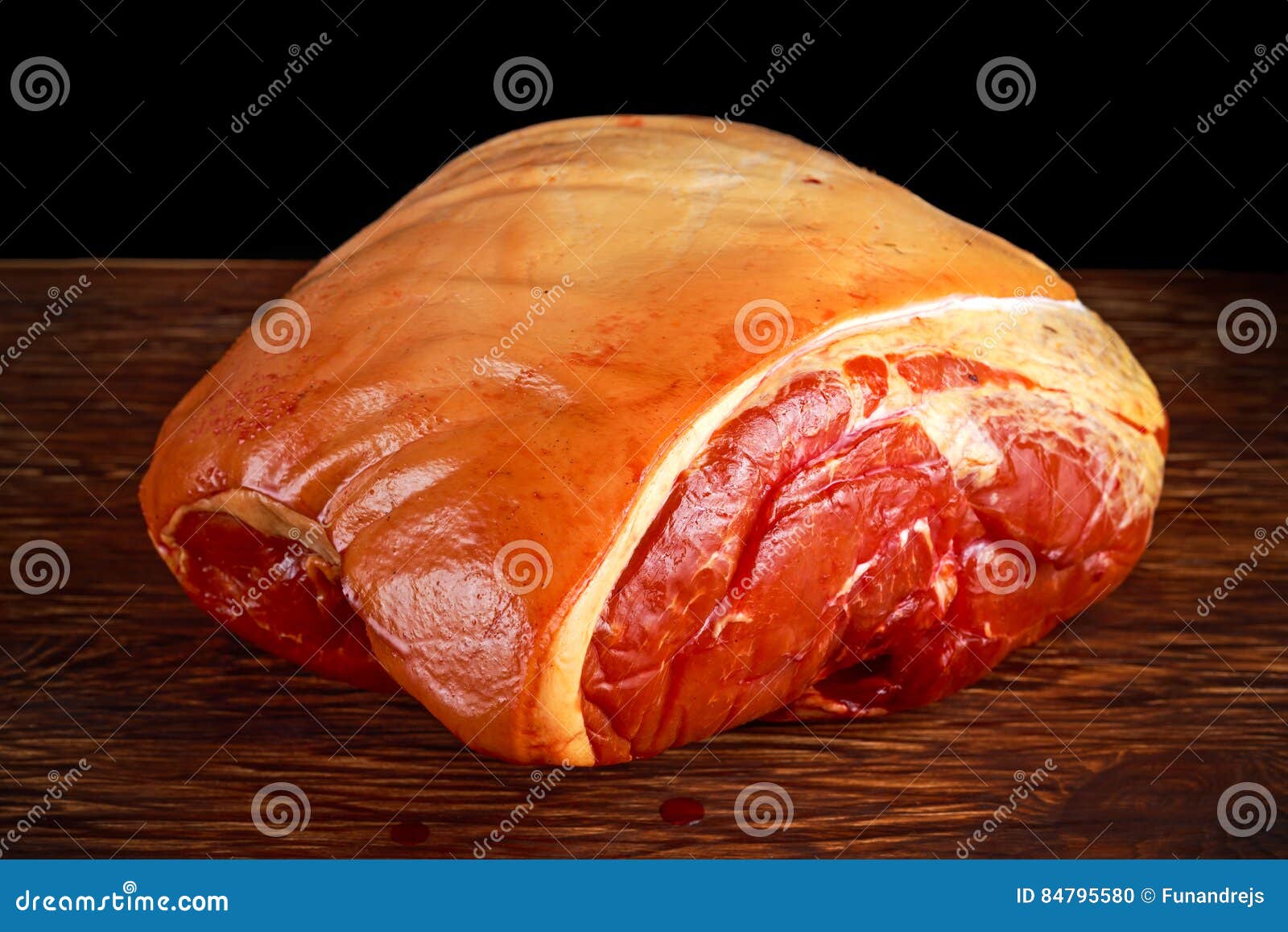 Raw Smoked Gammon Whole Bone in. on Black Board Background. Stock Photo