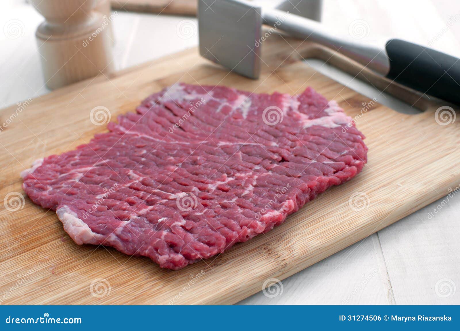 raw steak piece and meat pounder