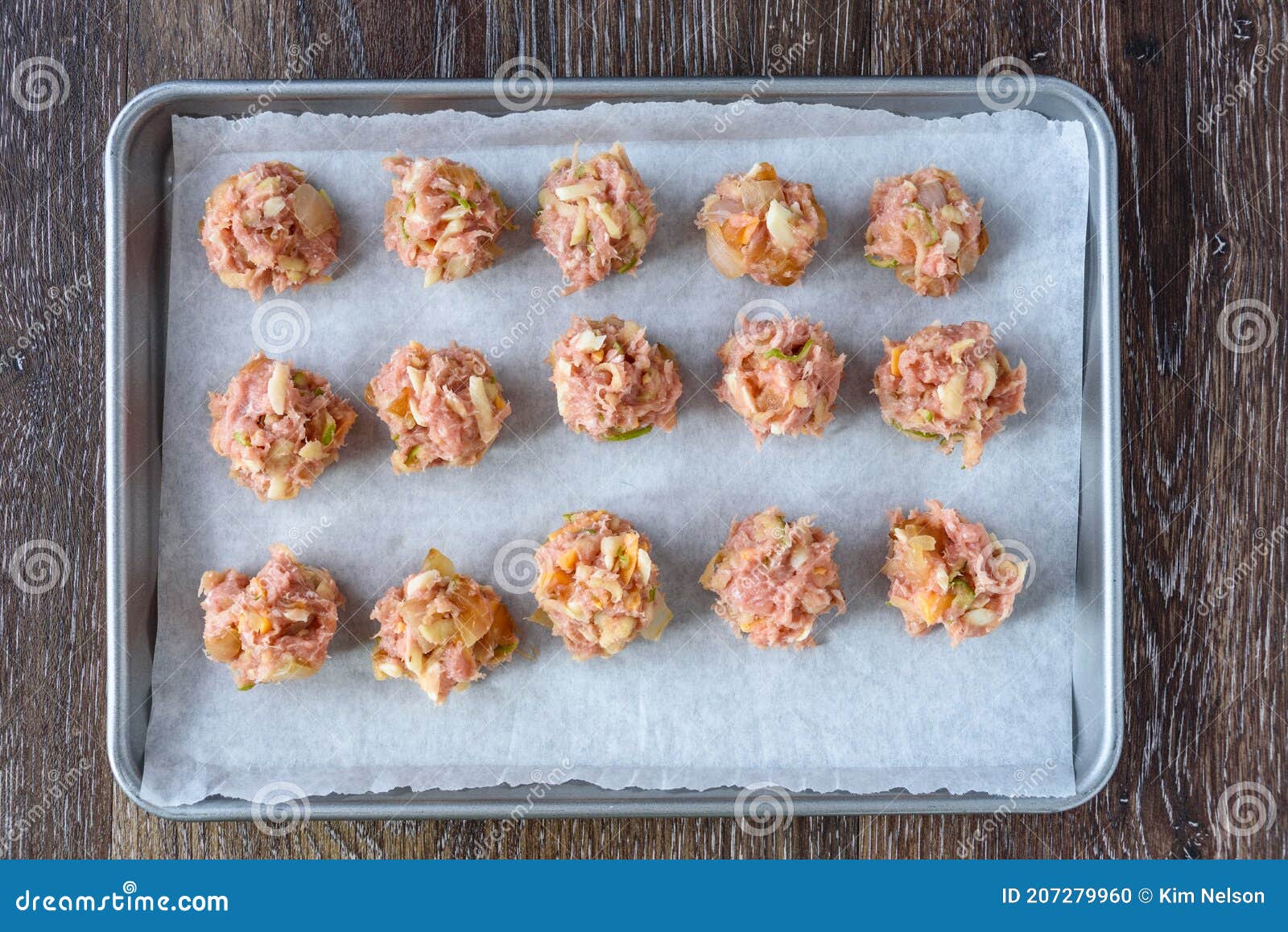 Raw Turkey Mixture Meatballs on a Parchment Paper Lined Baking Tray