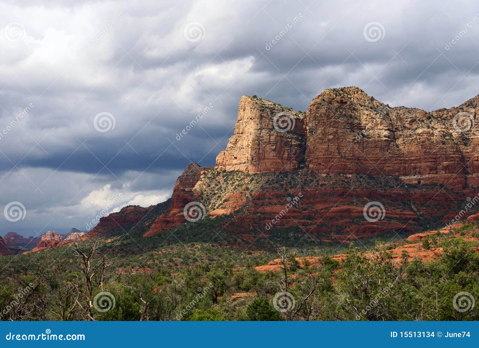 Rayos de sol pasados antes del rainstrorm. Montañas rojas en Sedona (Arizona, los E.E.U.U.) bajo las nubes de tormenta de la lluvia