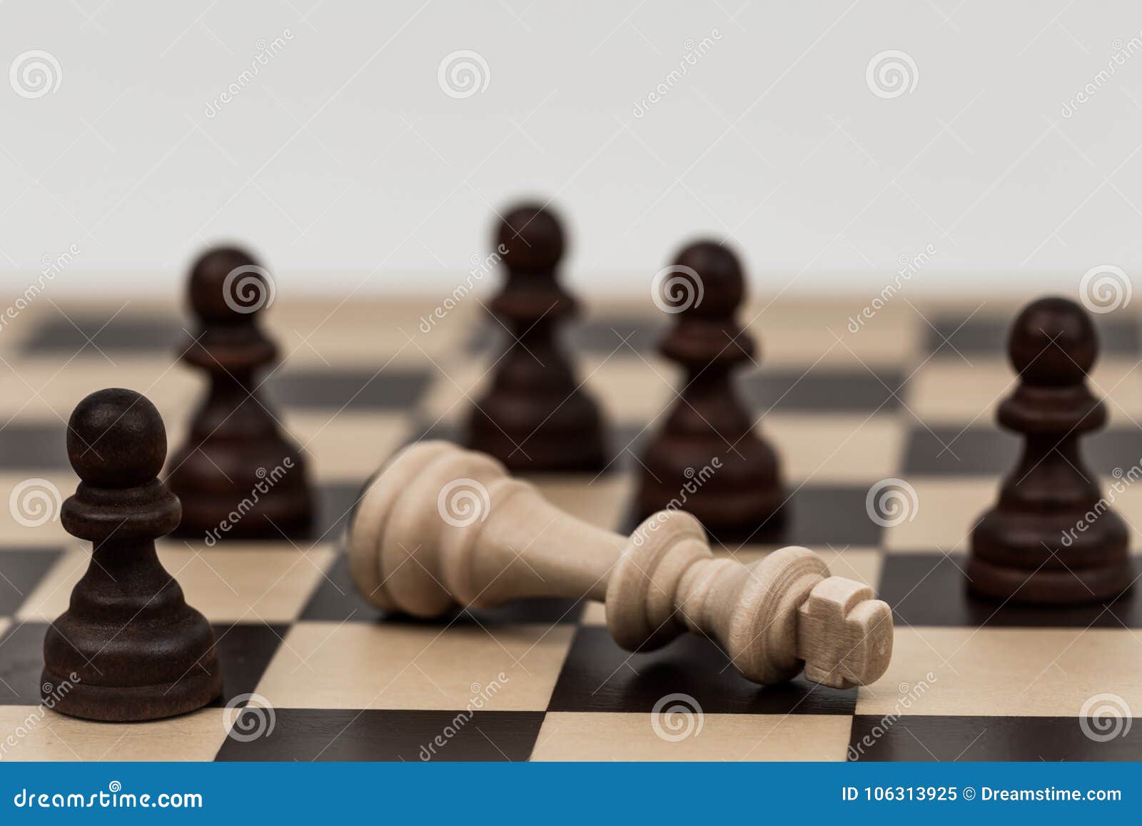 Re negli scacchi è caduto a parecchi pegni. Parecchi pegni battono e conquistano il re su questa scacchiera classica La strategia ed il lavoro di squadra possono sormontare la forza maggiore