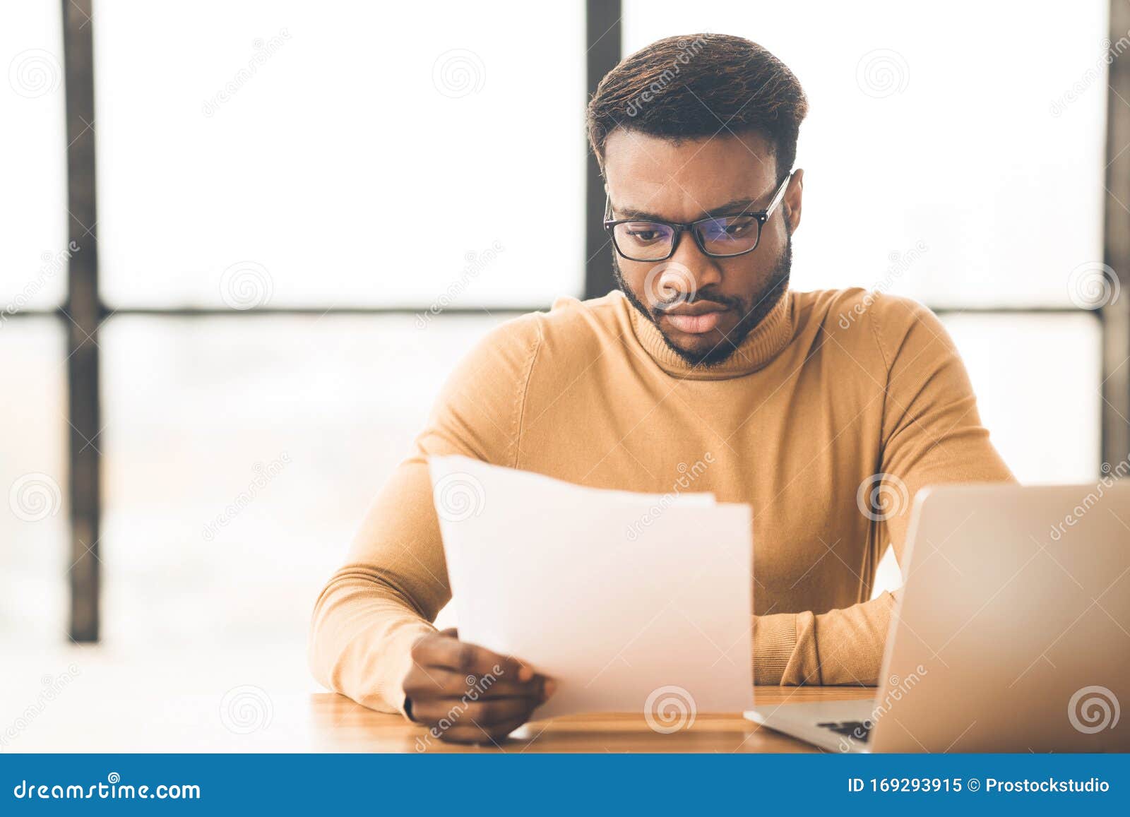 african american manager checking reports in modern office