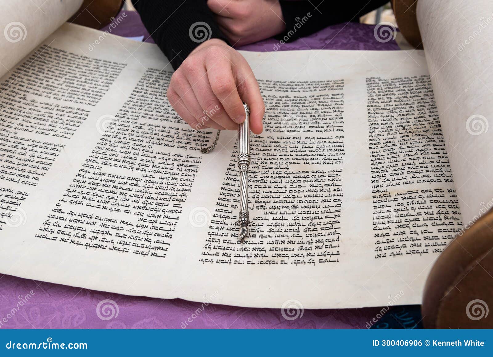 Reading the Torah scroll with the aid of a silver pointer or yad. A reader uses a pointer to guide his hand and eyes across the text of a Torah scroll during a Jewish prayer service