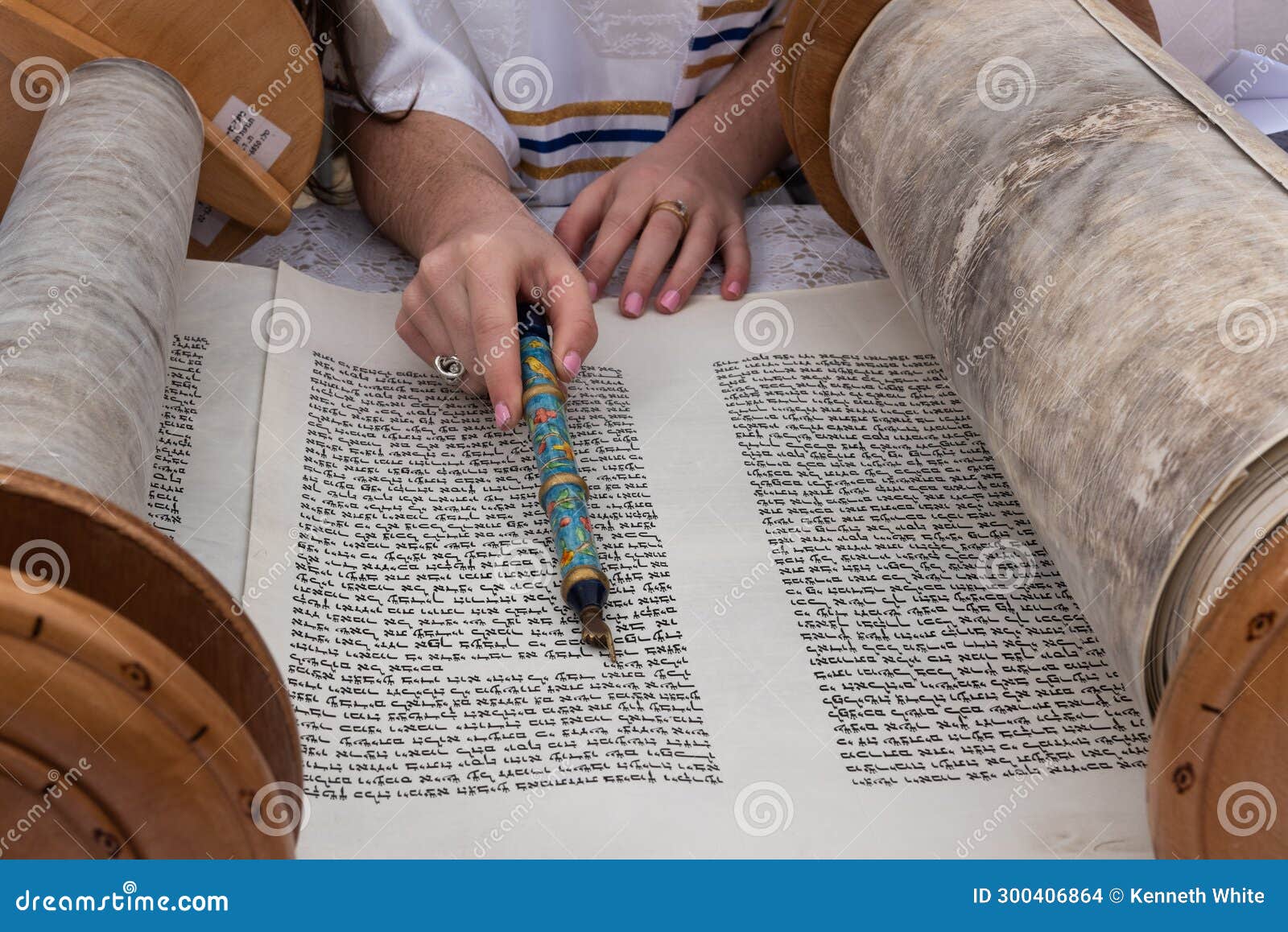 reading from the torah scroll using a colorful pointer or yad