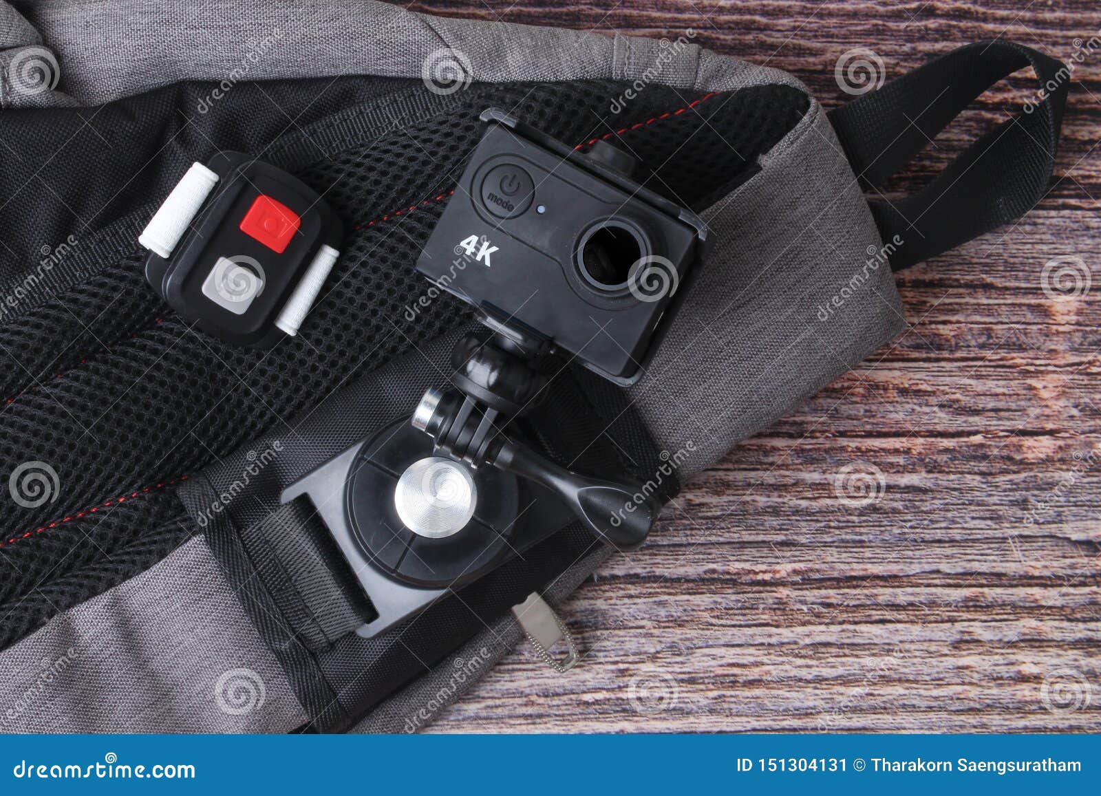 Ready Backpack and 4K Action Camera with Clip and Remote on Old Wood
