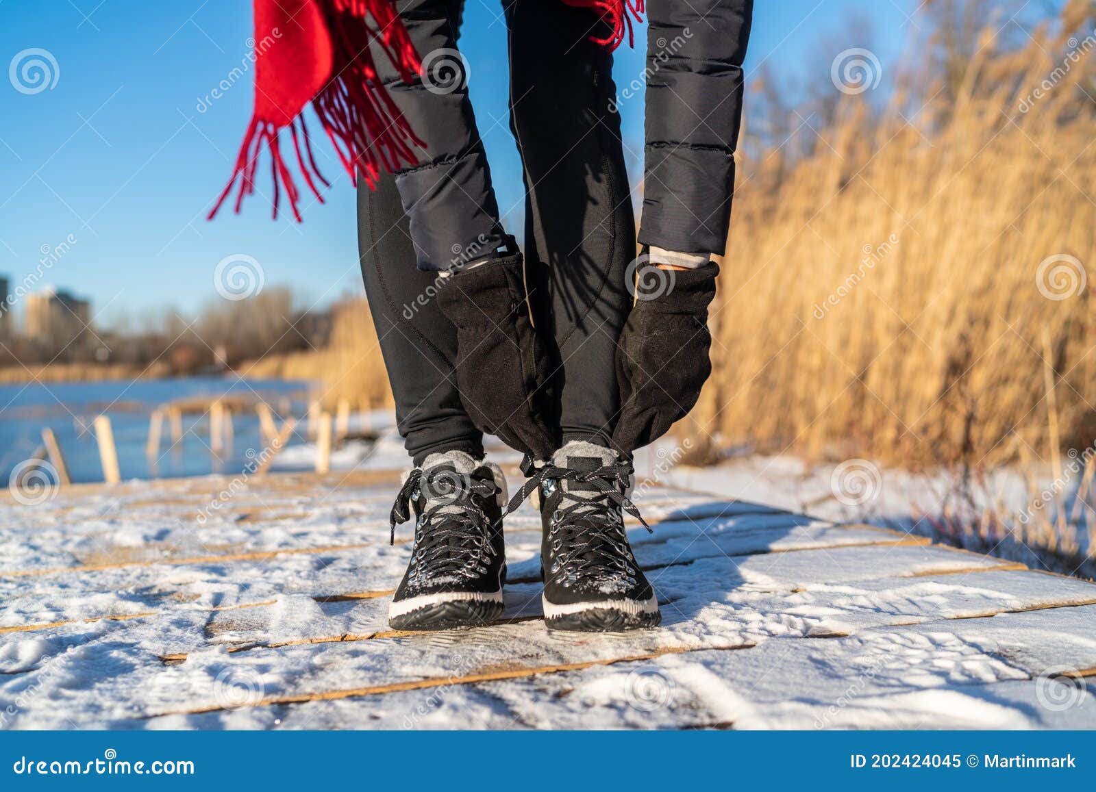 Ready for Winter Woman Tying Boot Laces Hiking Boots for Snow and Ice Anti Slippery Soles for