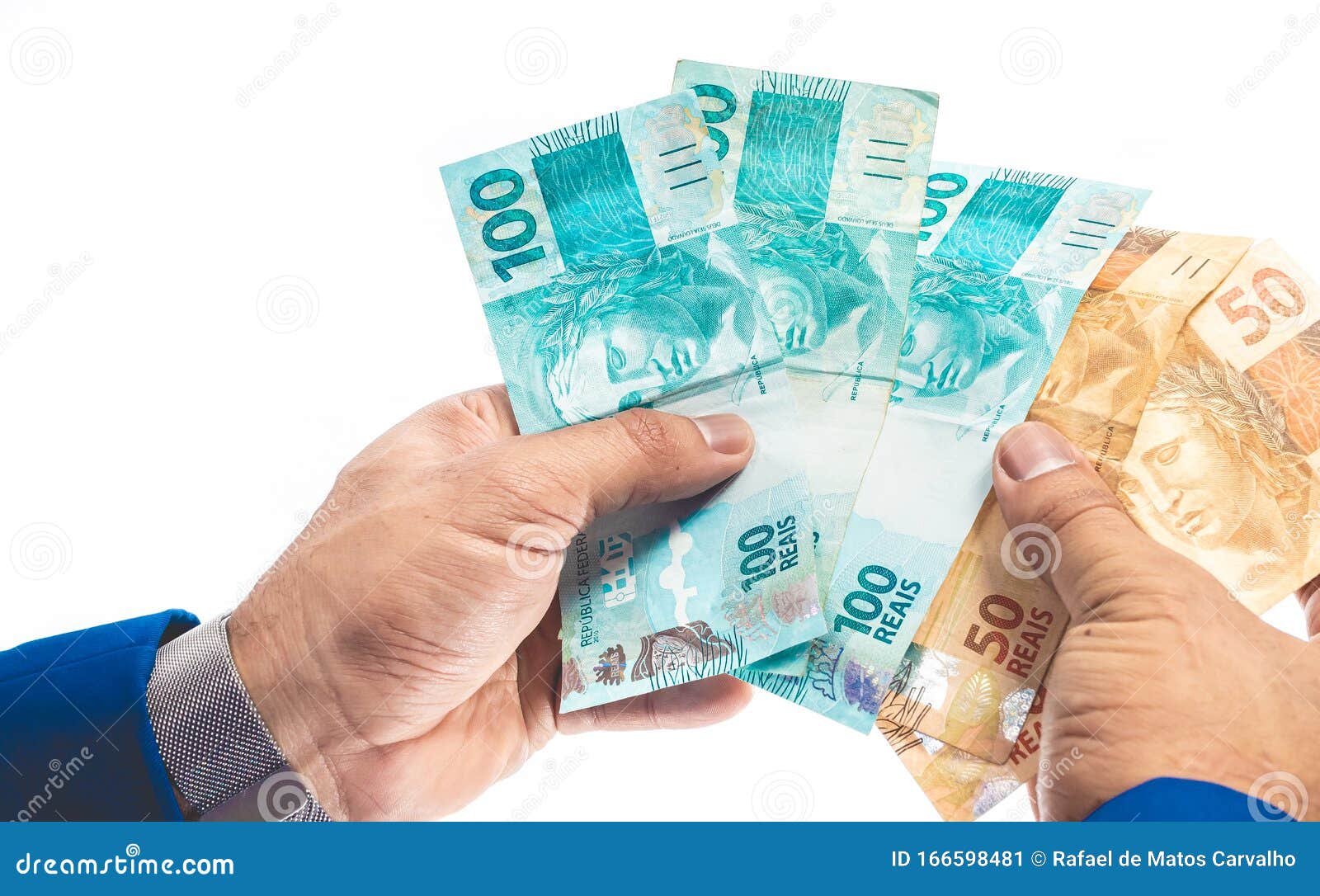 real - brazilian currency. man holding several money bills.
