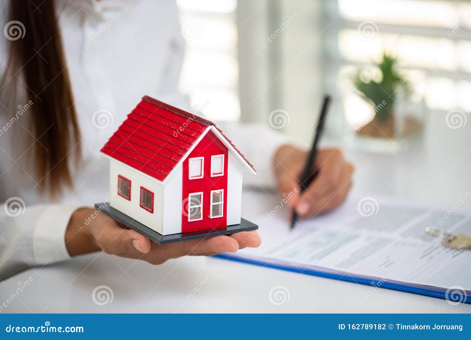 Real Estate Agent with House Model.Real Estate Agent Offer House