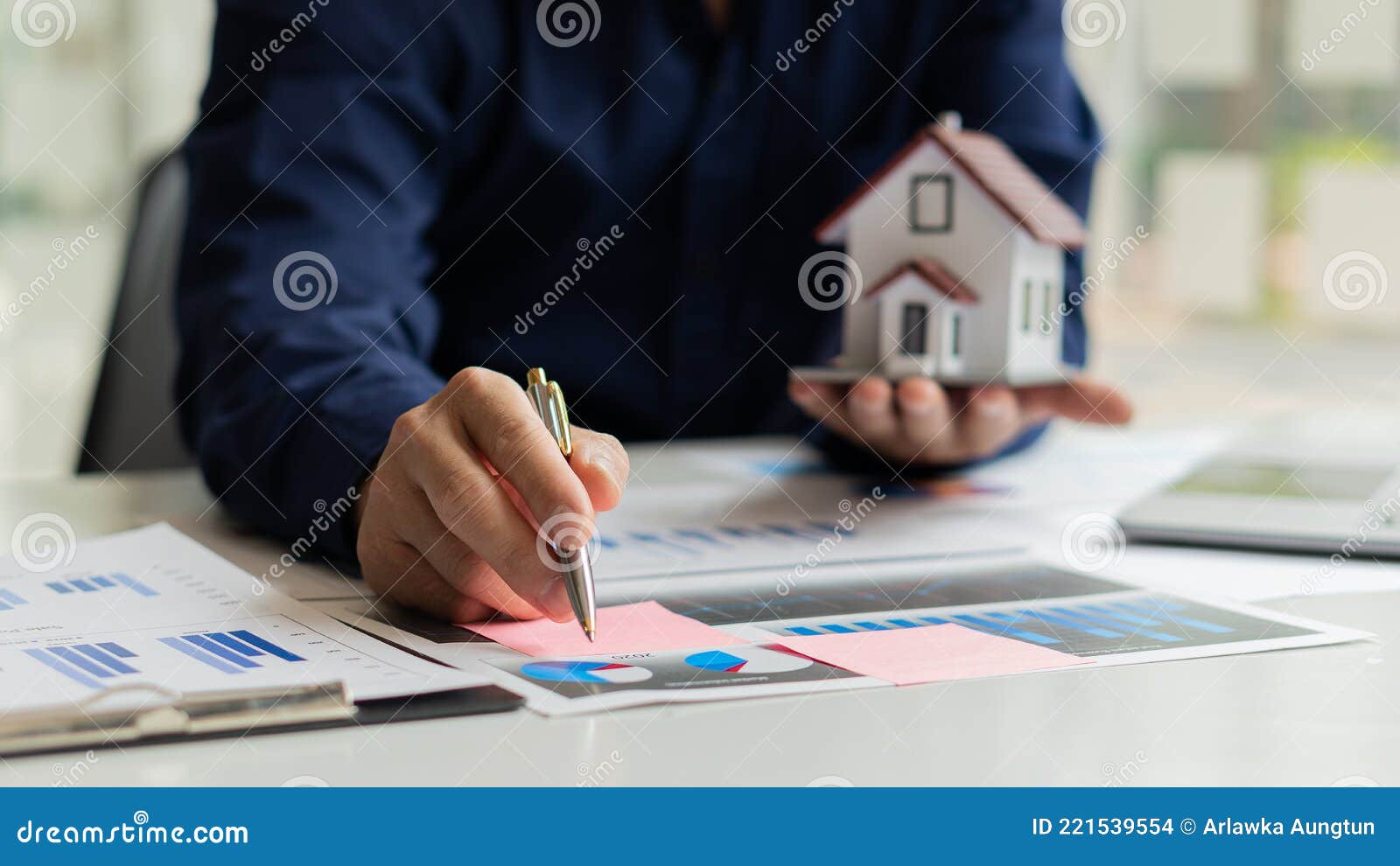 Real Estate Agents Work at Desks in Rooms with Paperwork and House