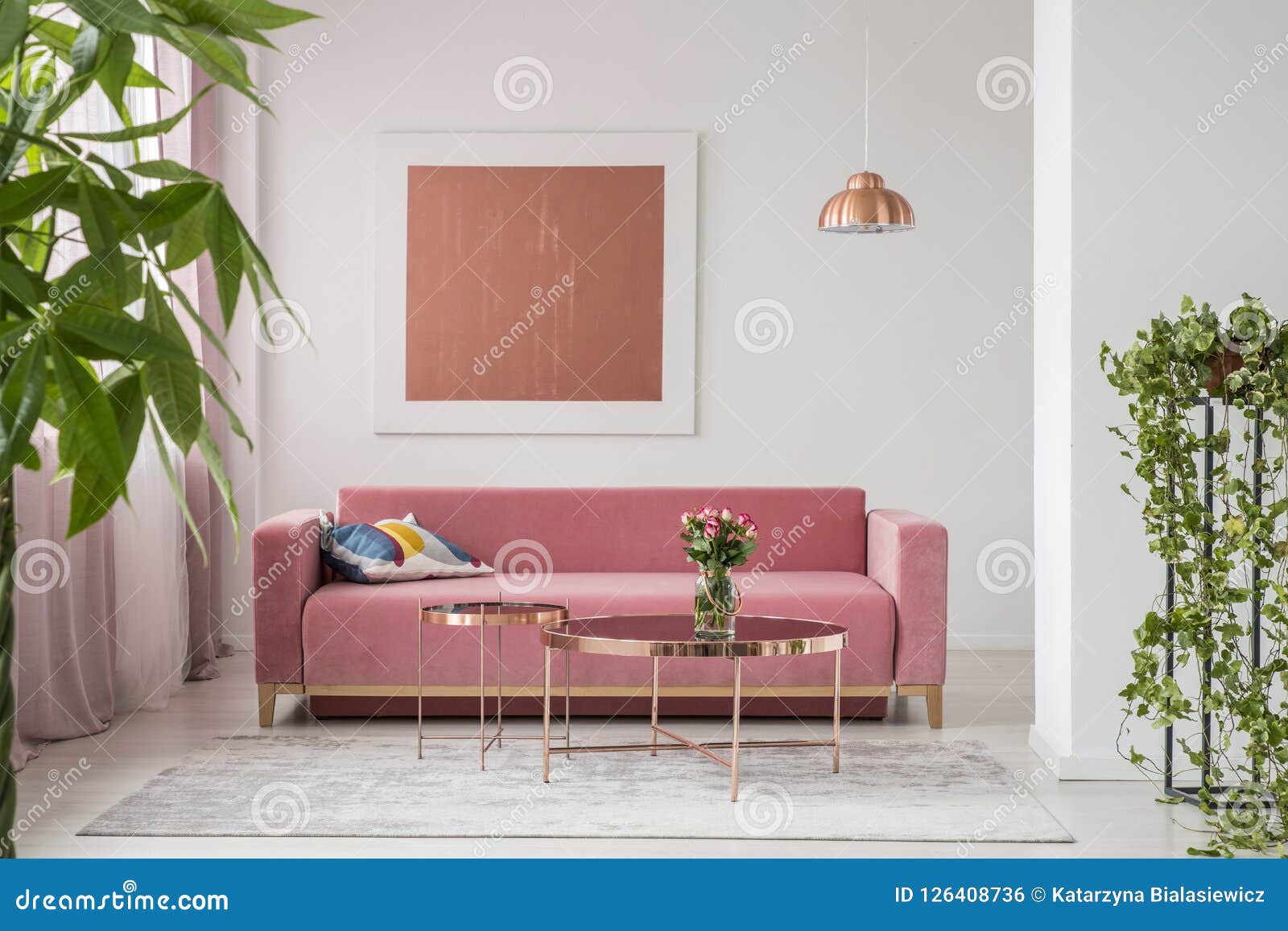 real photo of a pink couch, round coffee tables and painting in a modern living room interior