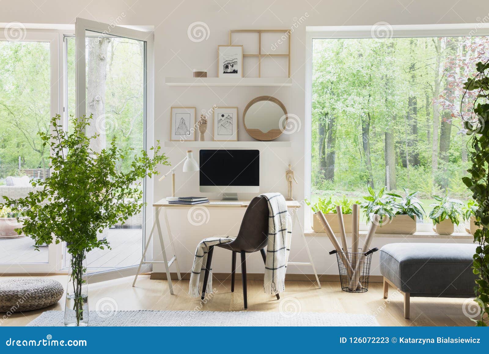 real photo of white living room interior with big window, glass door, fresh plants, wooden desk with mockup computer and simple po
