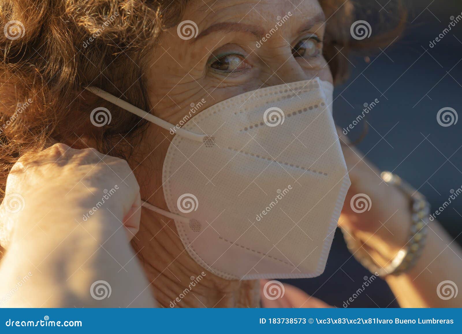 a real woman shows how to put on the protective mask to prevent the spread of the covid-19