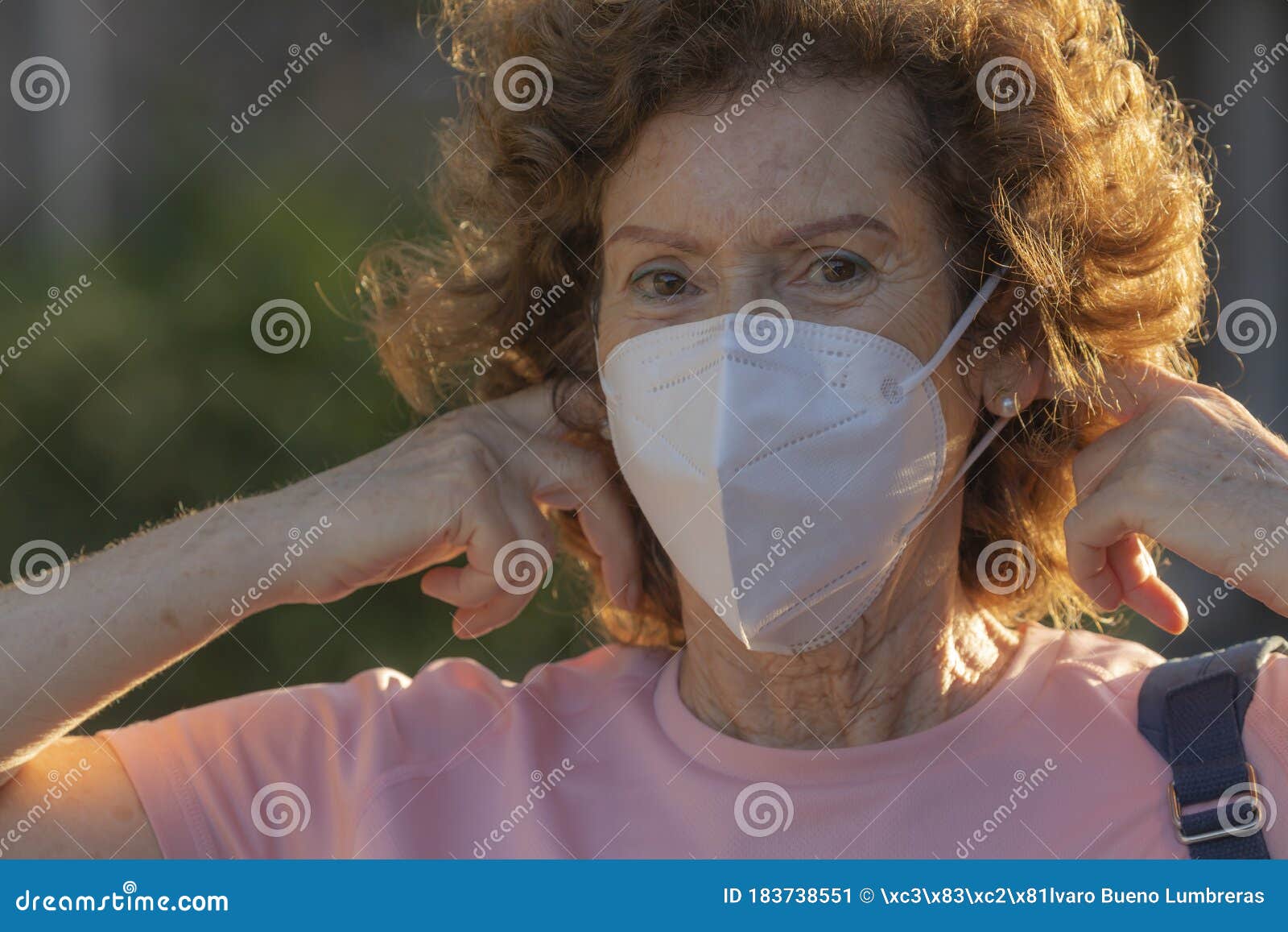 a real woman shows how to put on the protective mask to prevent the spread of the covid-19