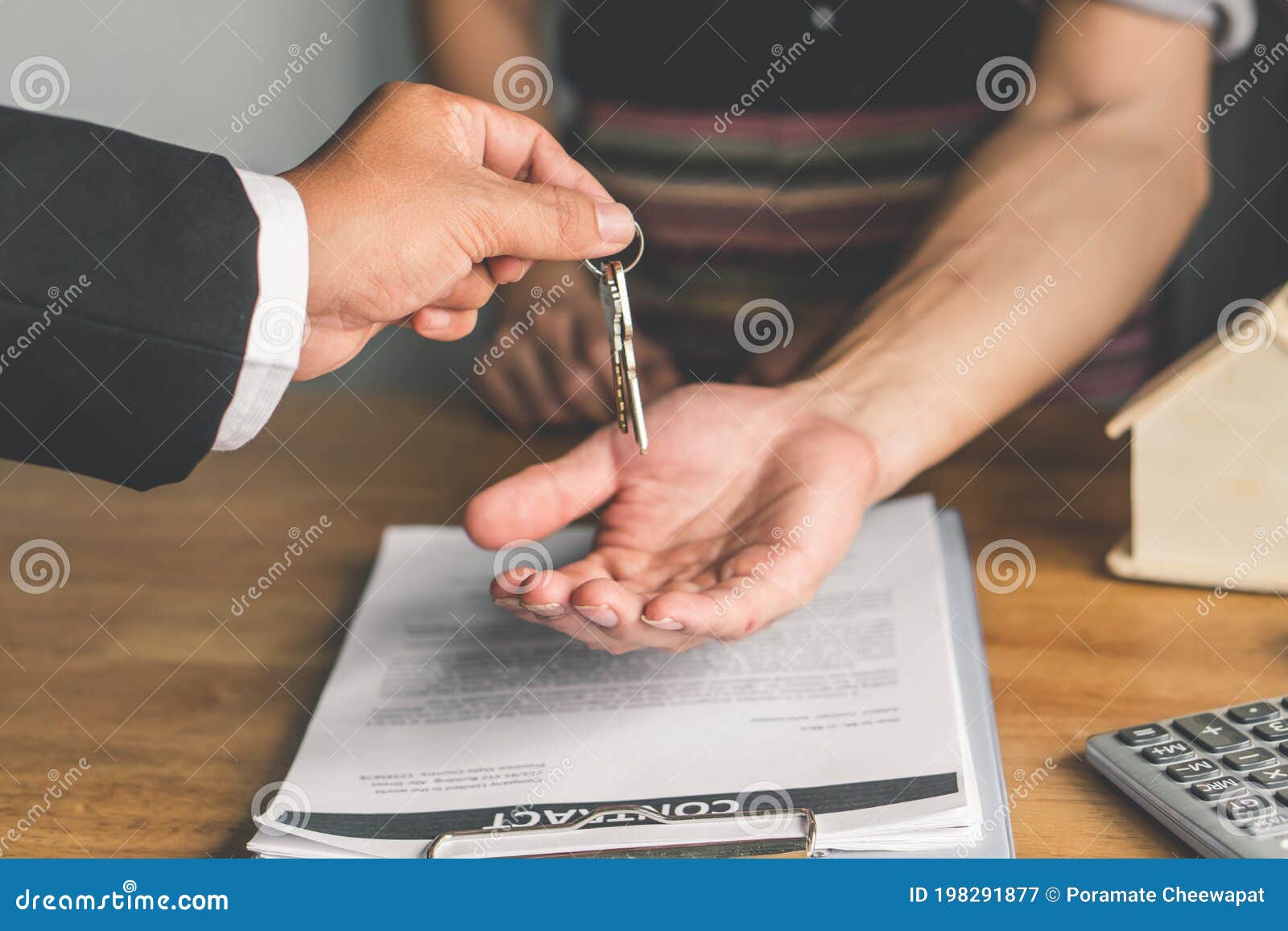realtor agent giving a key of apartment to new owner after signed lease agreement
