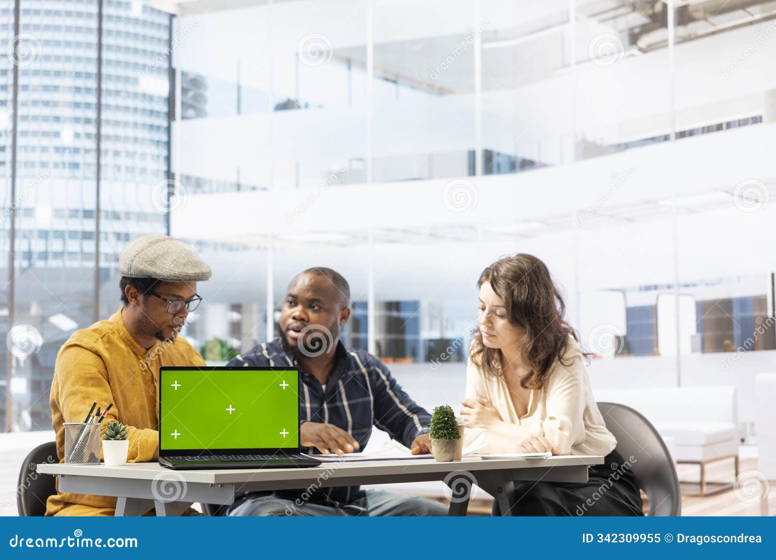 realtors and client evaluating blueprints next to green screen display