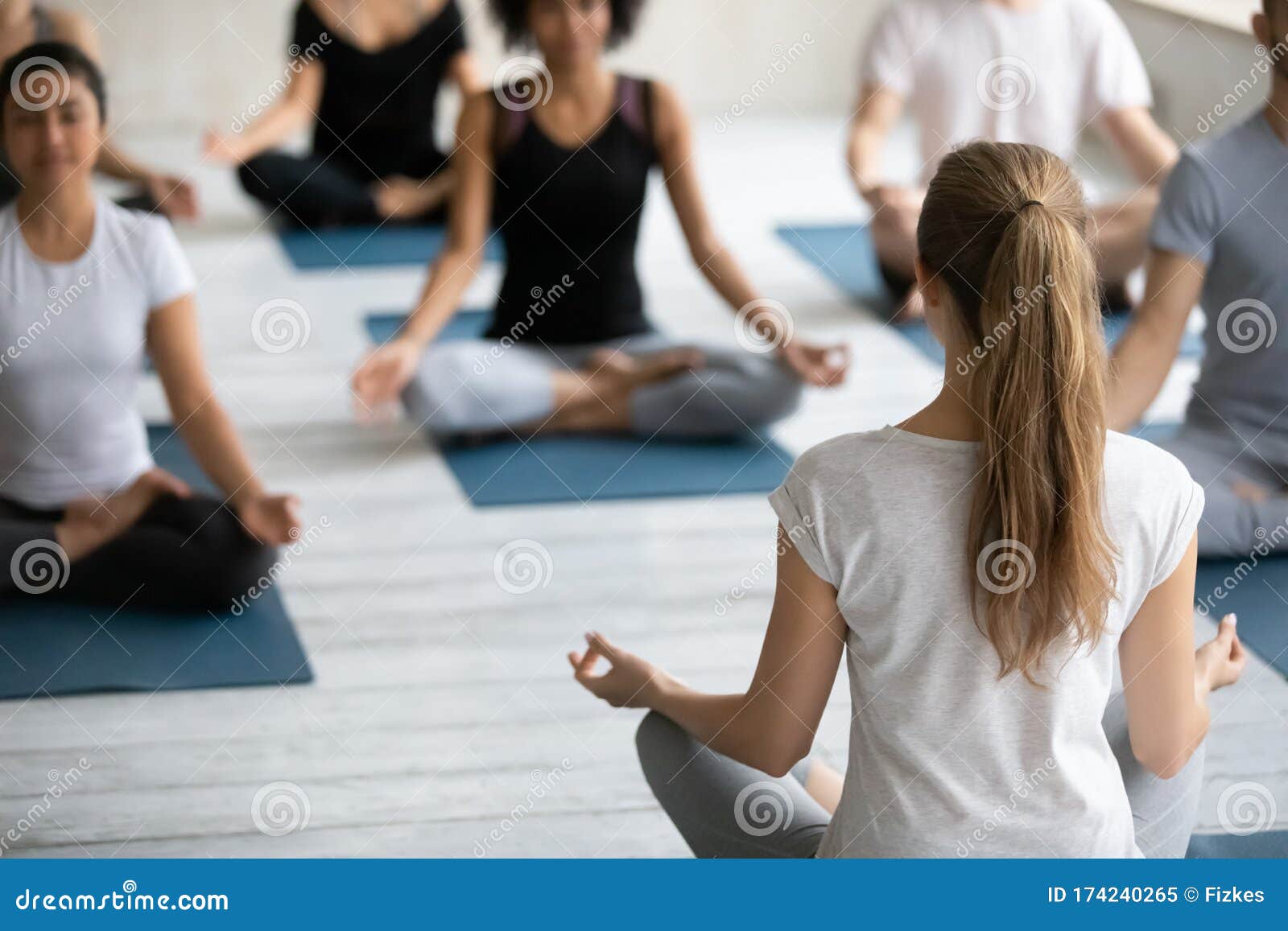 Coach And Group Of People Meditating Seated In Lotus Pose ...