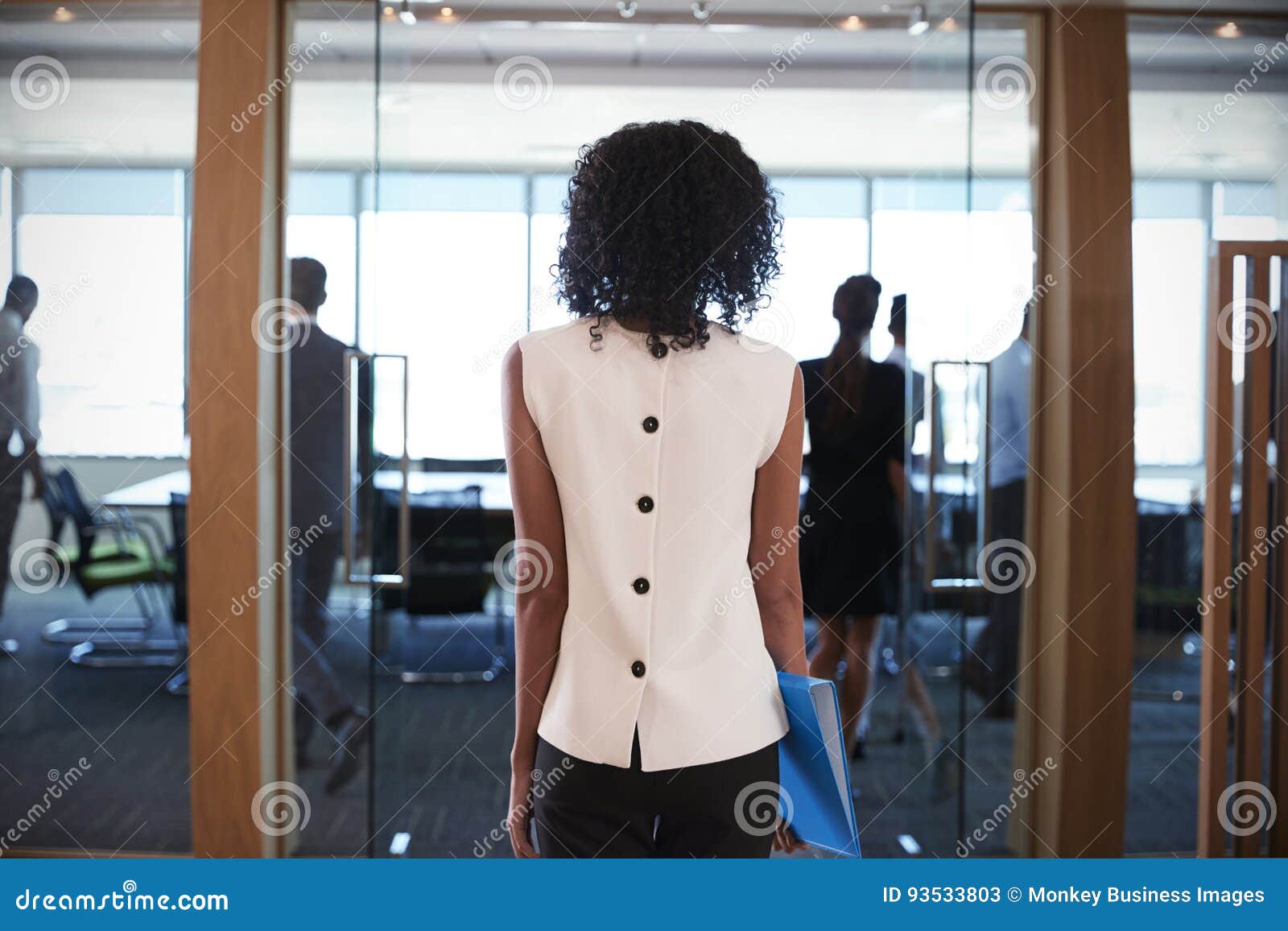 rear view of businesswoman entering boardroom for meeting