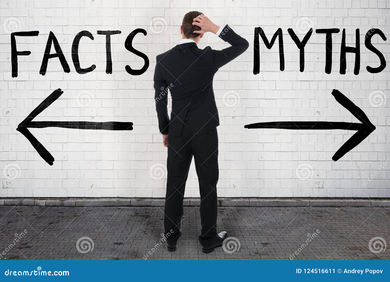 businessman looking at arrow signs below facts and myths