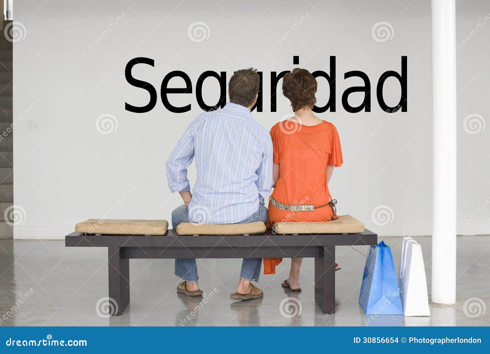 rear view of couple reading spanish text seguridad (security) and contemplating it