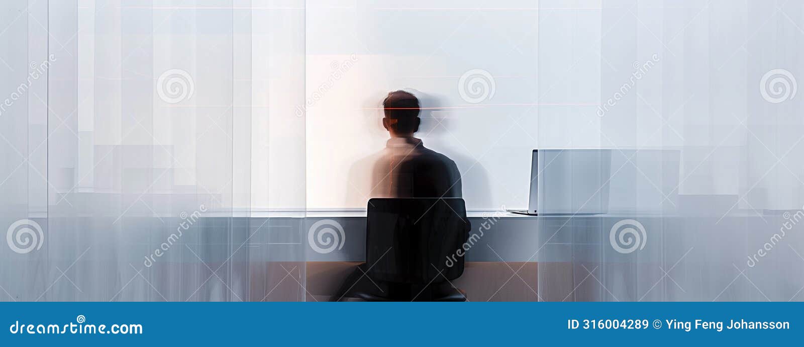 rear view of lonely businessman in blurred motion working in solitude on laptop.