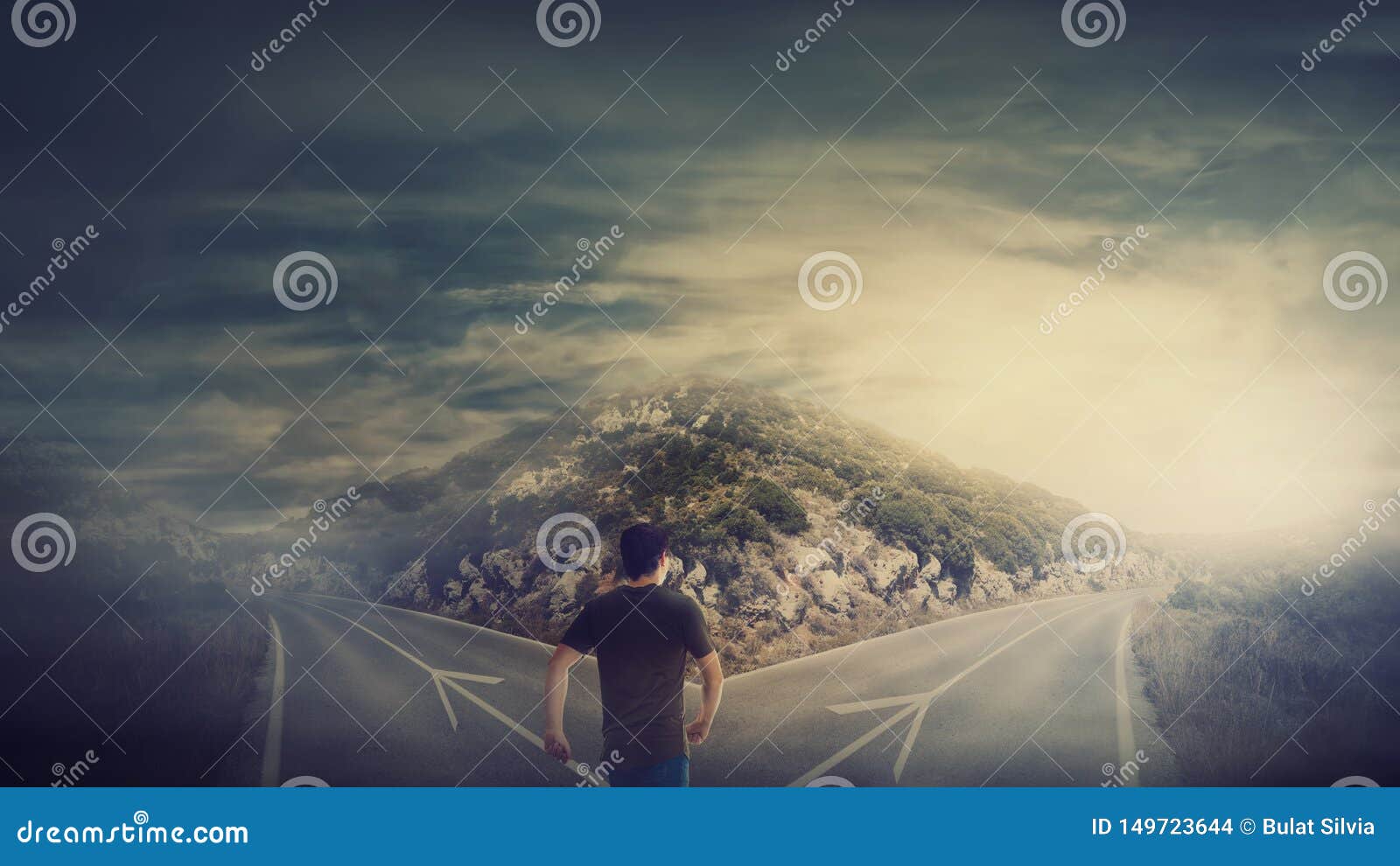 rear view man walking in front of crossroad as road is split in two different ways. choosing the correct path between left and