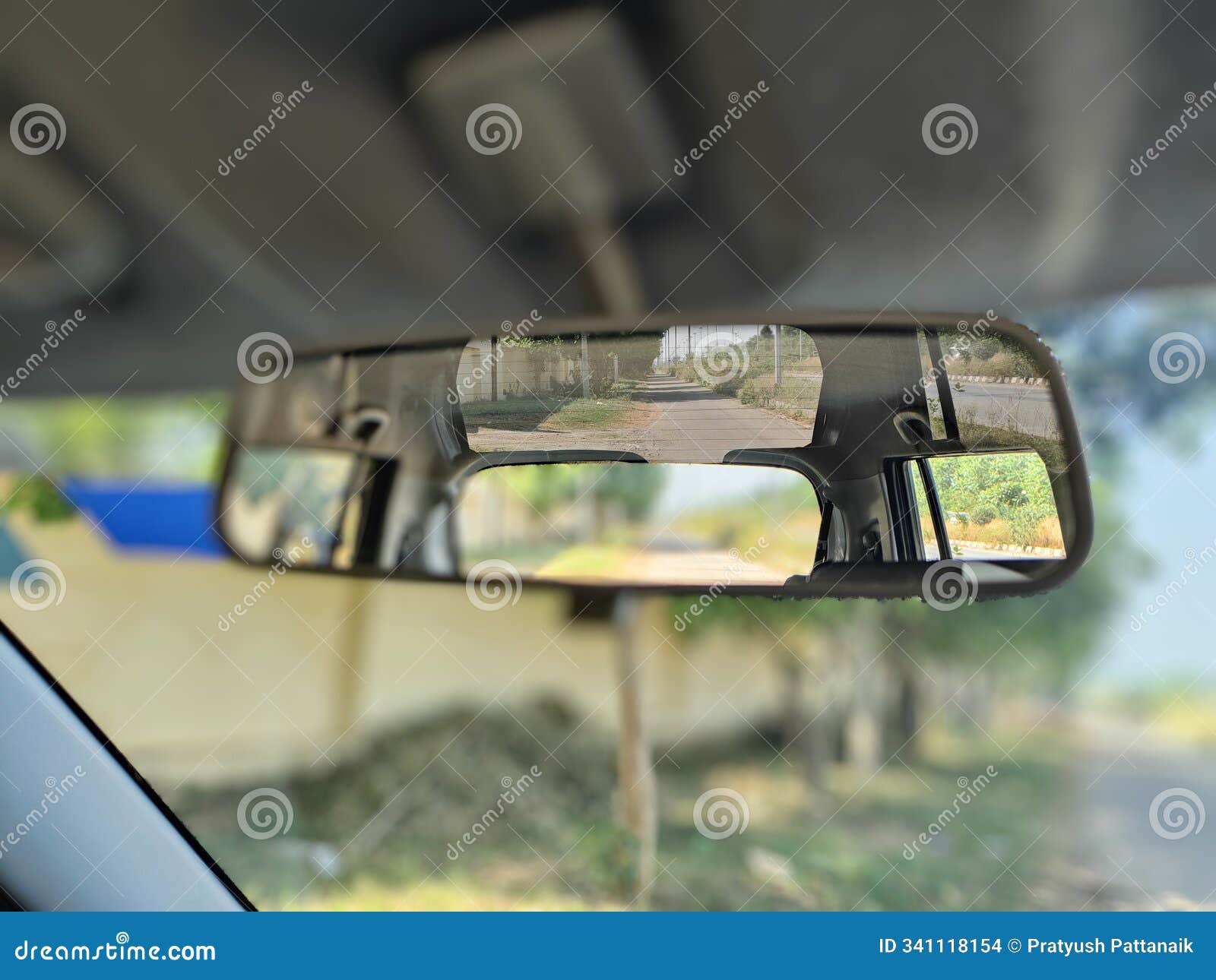 rear-view mirror reflection: a peaceful road stretch captured from inside a moving vehicle