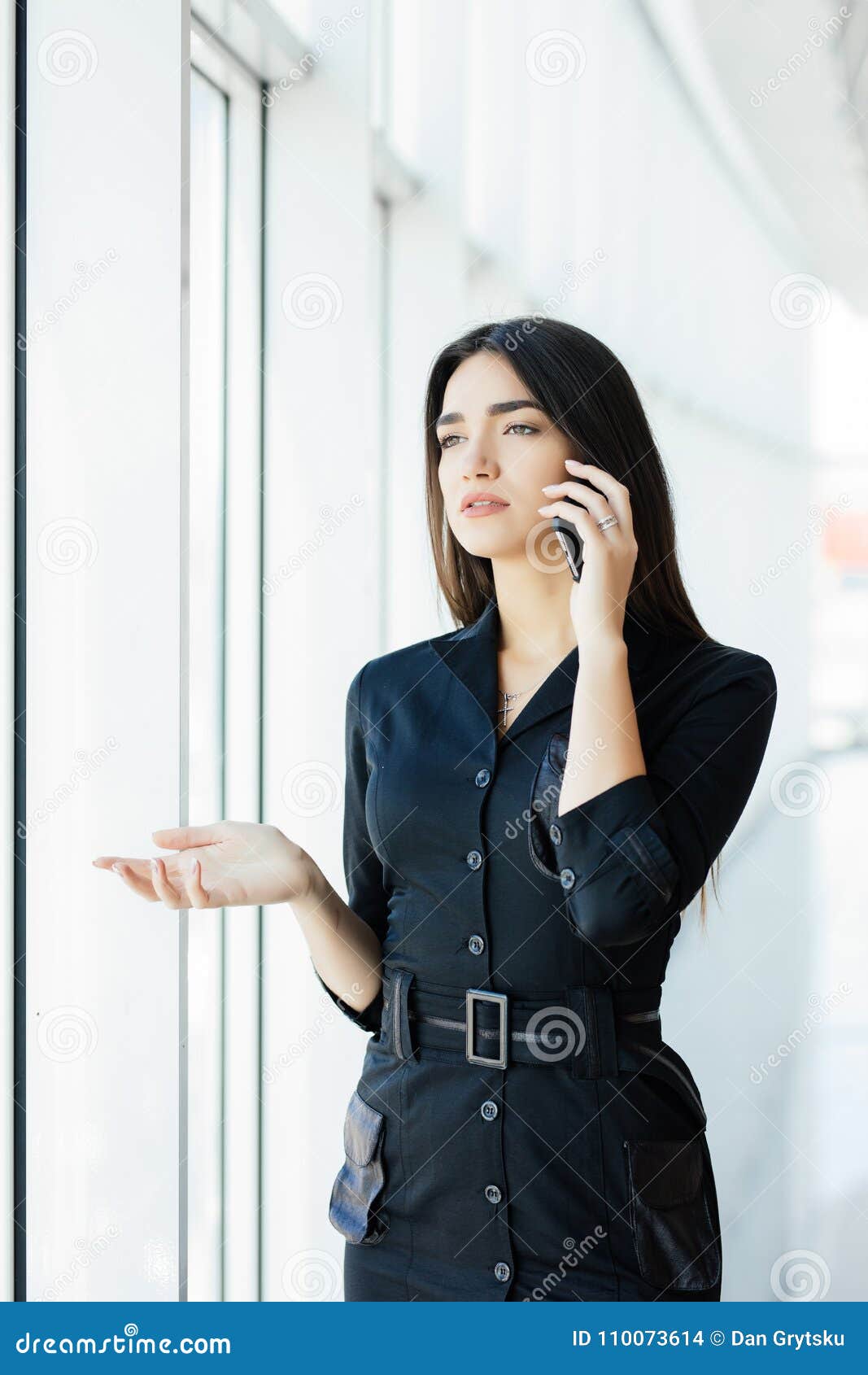 Portrait of Young Worker Speaking Using Cell Phone, Looking Out the ...
