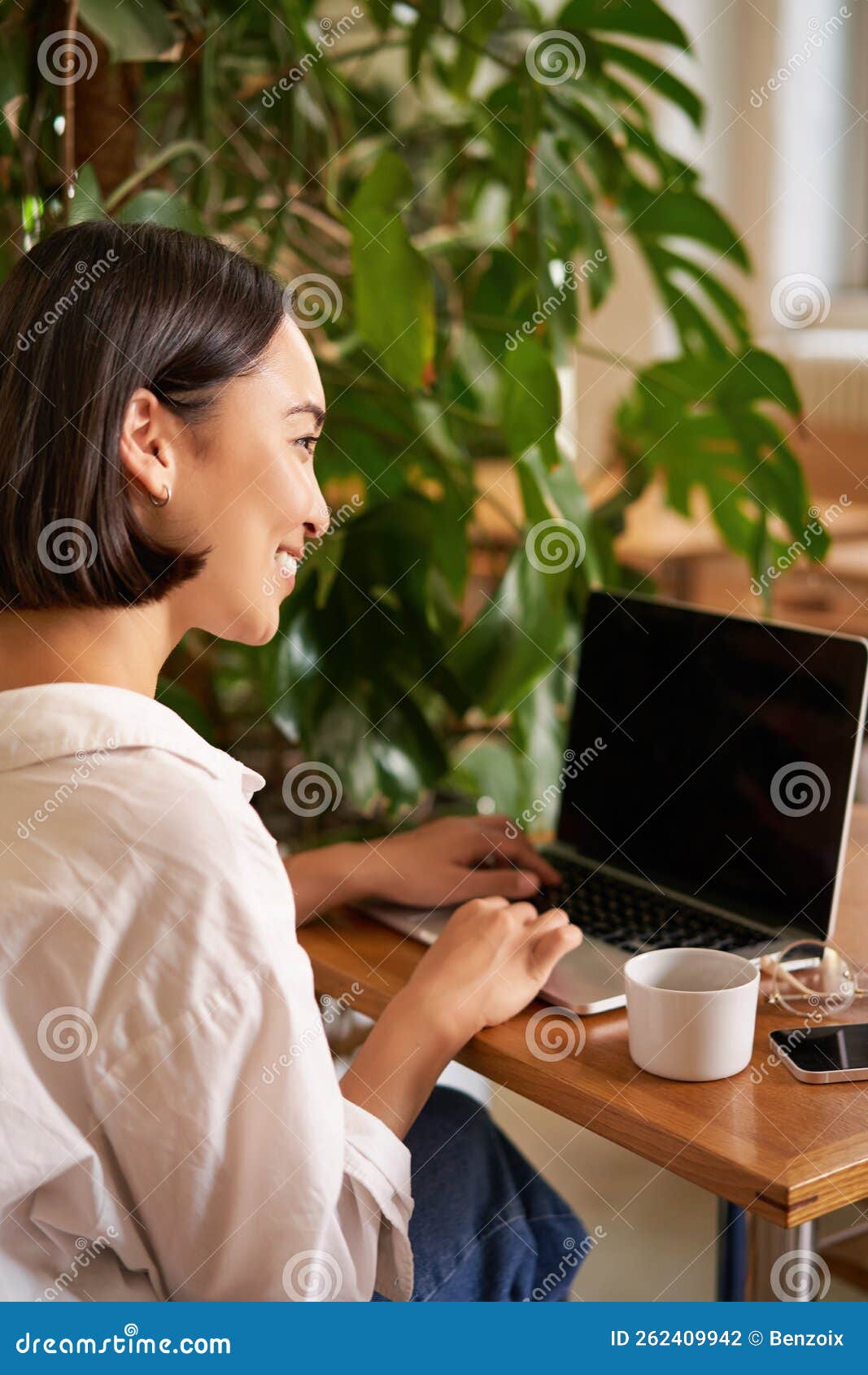 rear view of young asian woman and laptop screen, sitting in cafe and working, video chatting, chatting with someone