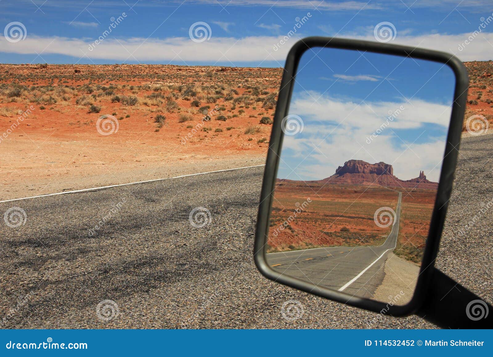 rearview mirror view of the road running through monument valley, utah