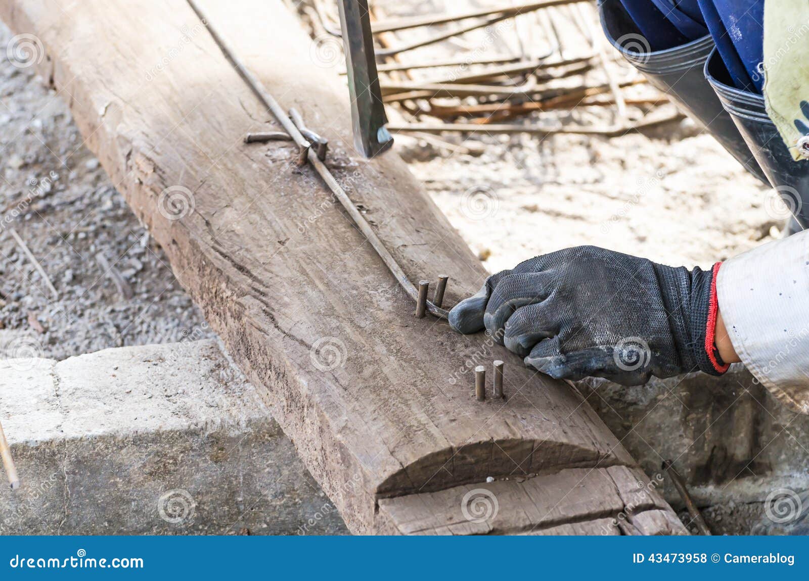 Rebar som böjer vid arbetaren i konstruktionsplats. Närbildarbetarhänder som böjer betong som förstärker metallstänger vid böjapparatutrustning