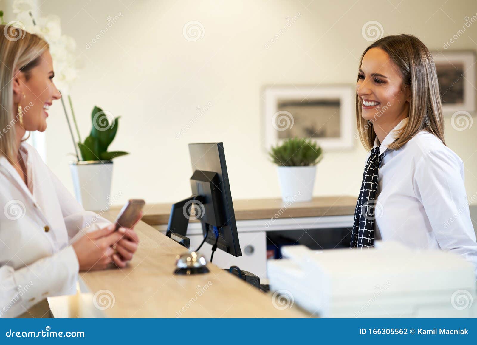 Receptionist And Businesswoman At Hotel Front Desk Stock Photo