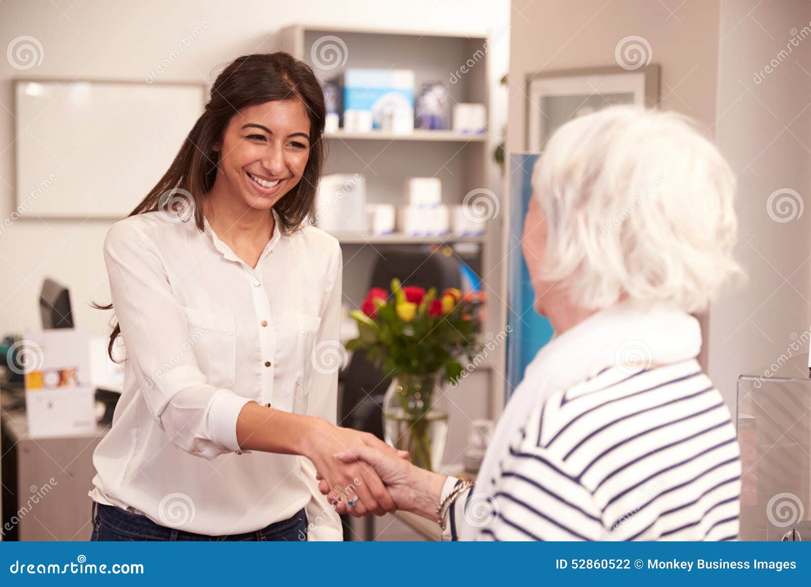 receptionist greeting female patient at hearing clinic