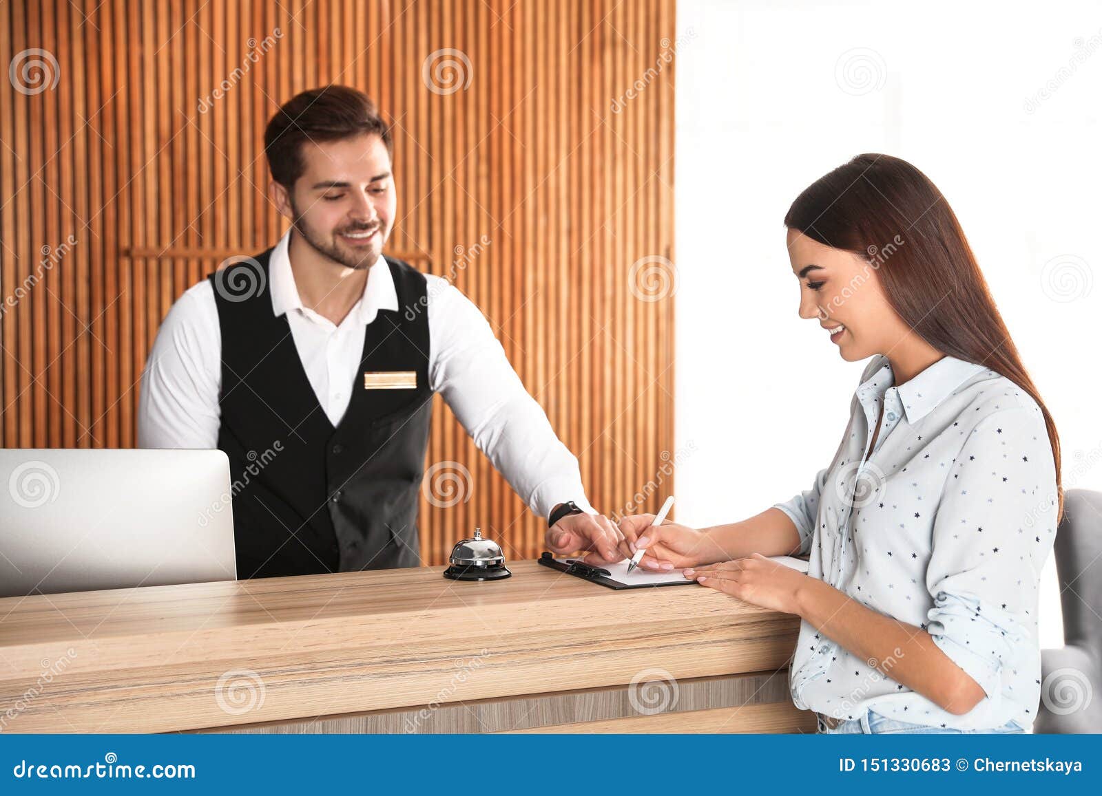 Receptionist Registering Client At Desk Stock Image - Image of client