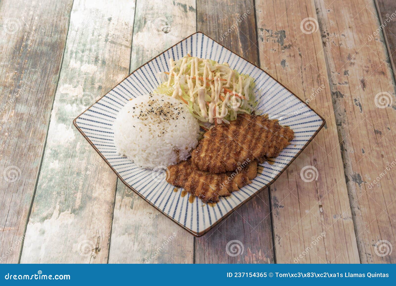 asian recipe for crispy pork tenderloin with yakitori sauce, vegetable salad and white rice with sesame