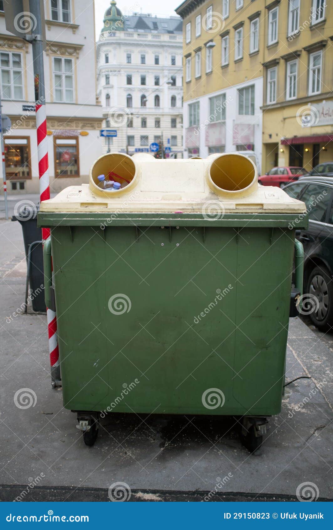 Recicl o lixo. Um único escaninho de recicl cercado por construções