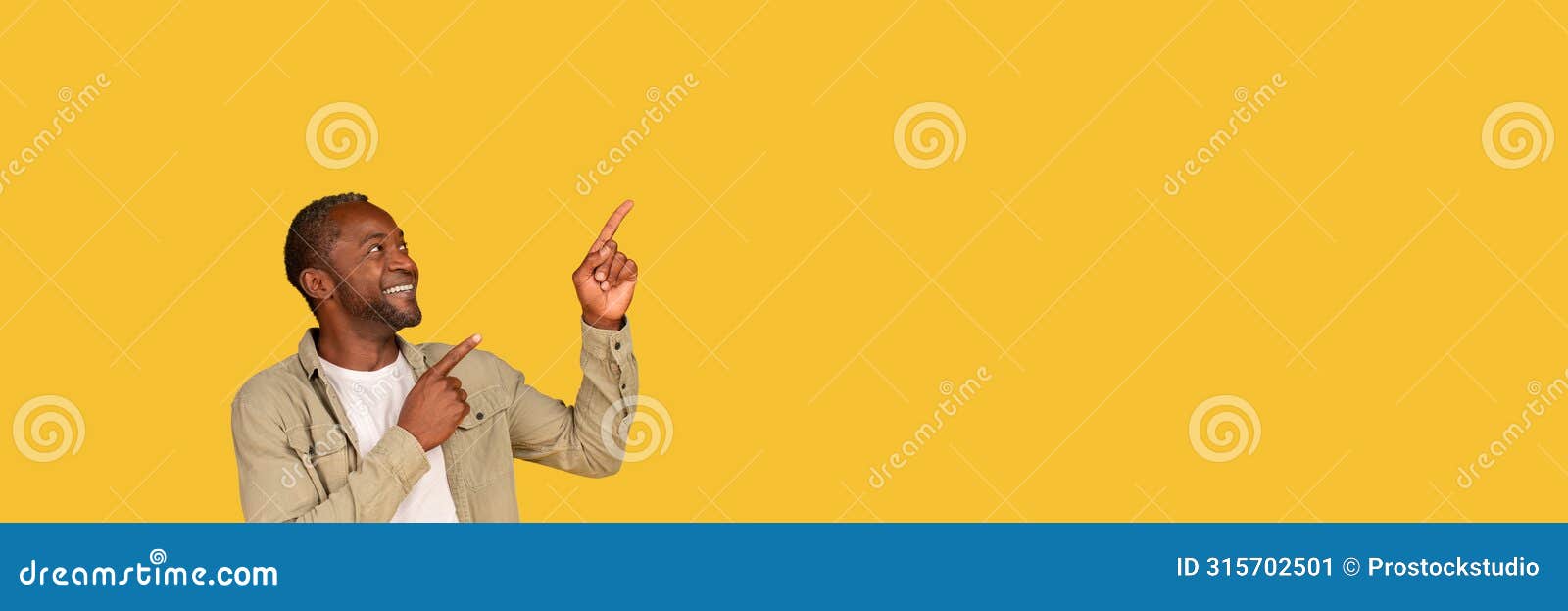 glad middle aged african american man pointing at empty space