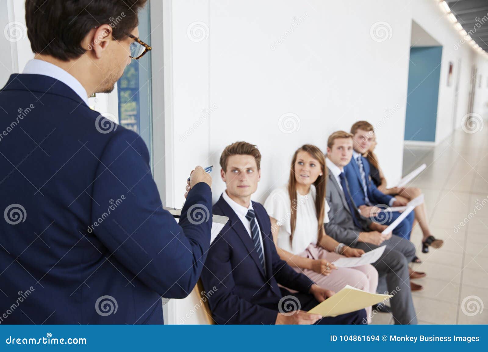 recruiter addressing job candidates waiting for interviews