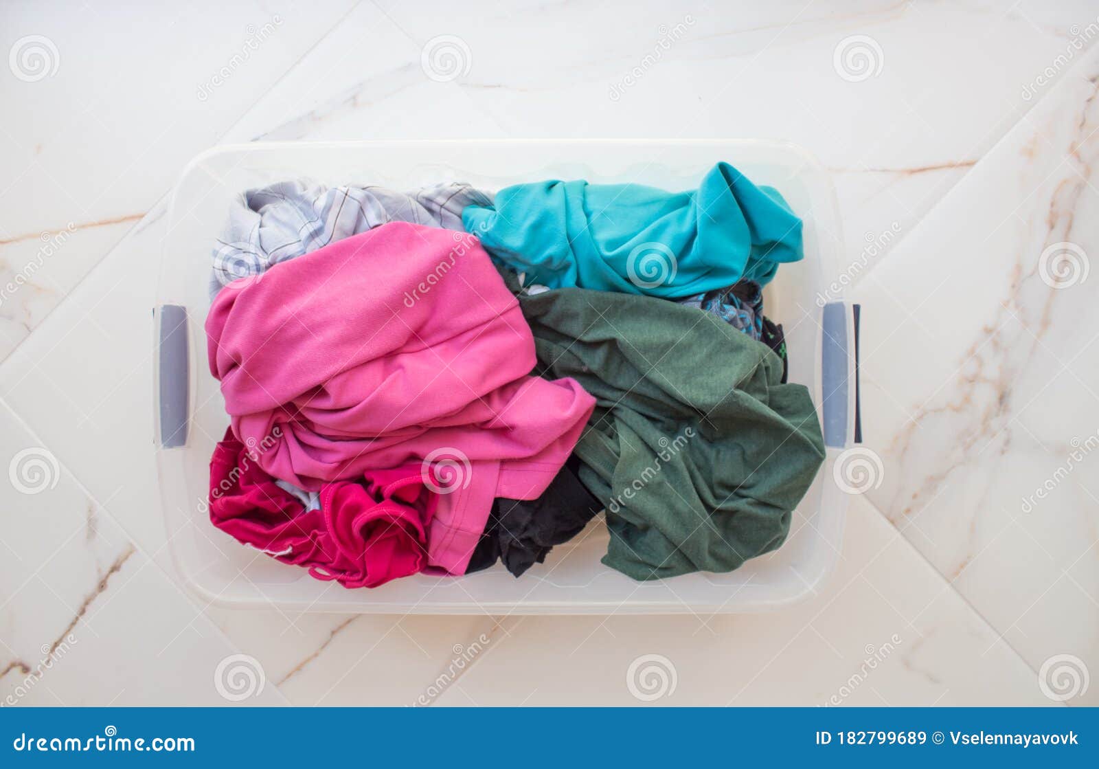 Rectangular Basket with Dirty Linen on a White Marble Floor Closeup